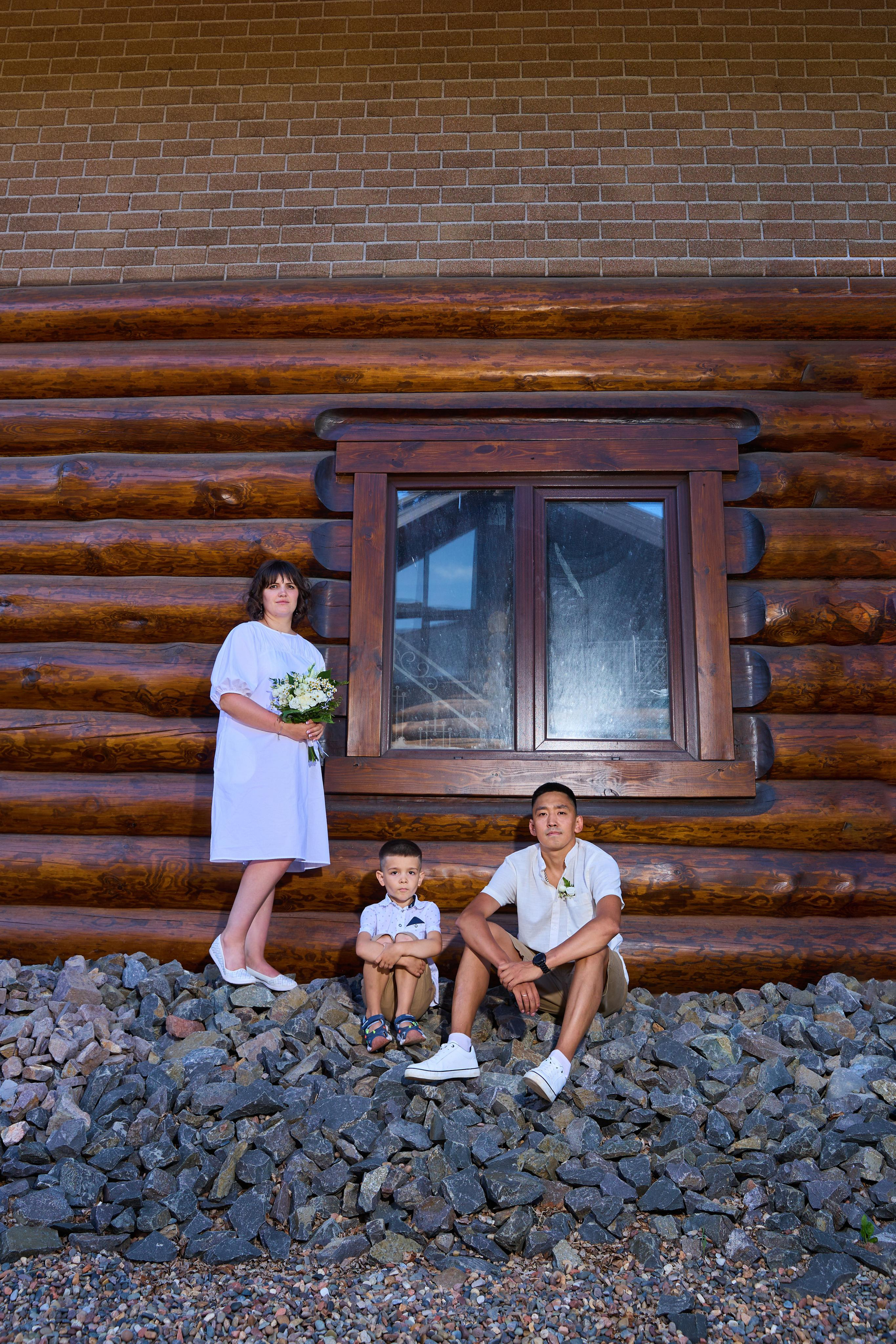 На фоне окна дома мама, папа и сын