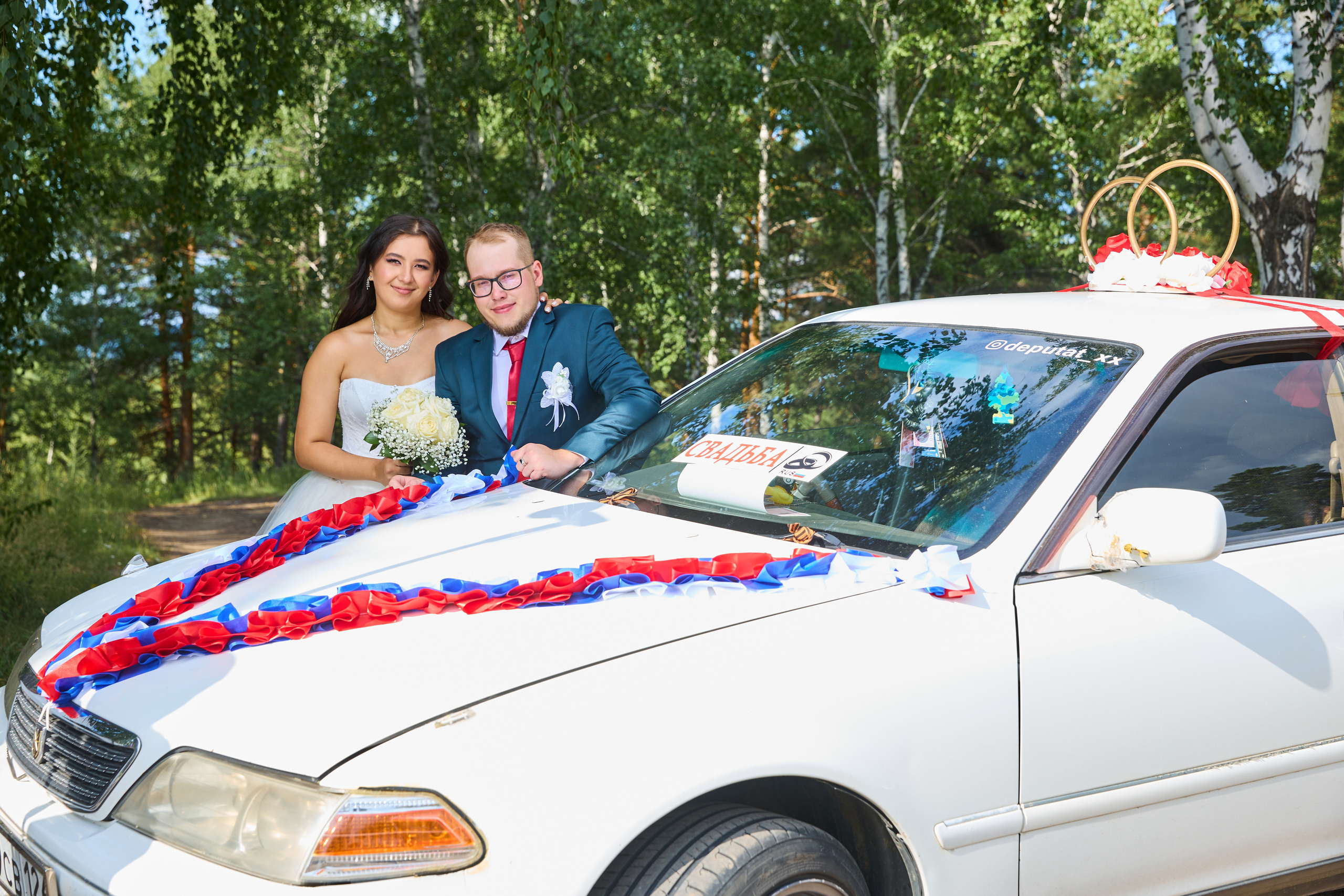 жених и невеста на фоне украшенной машины