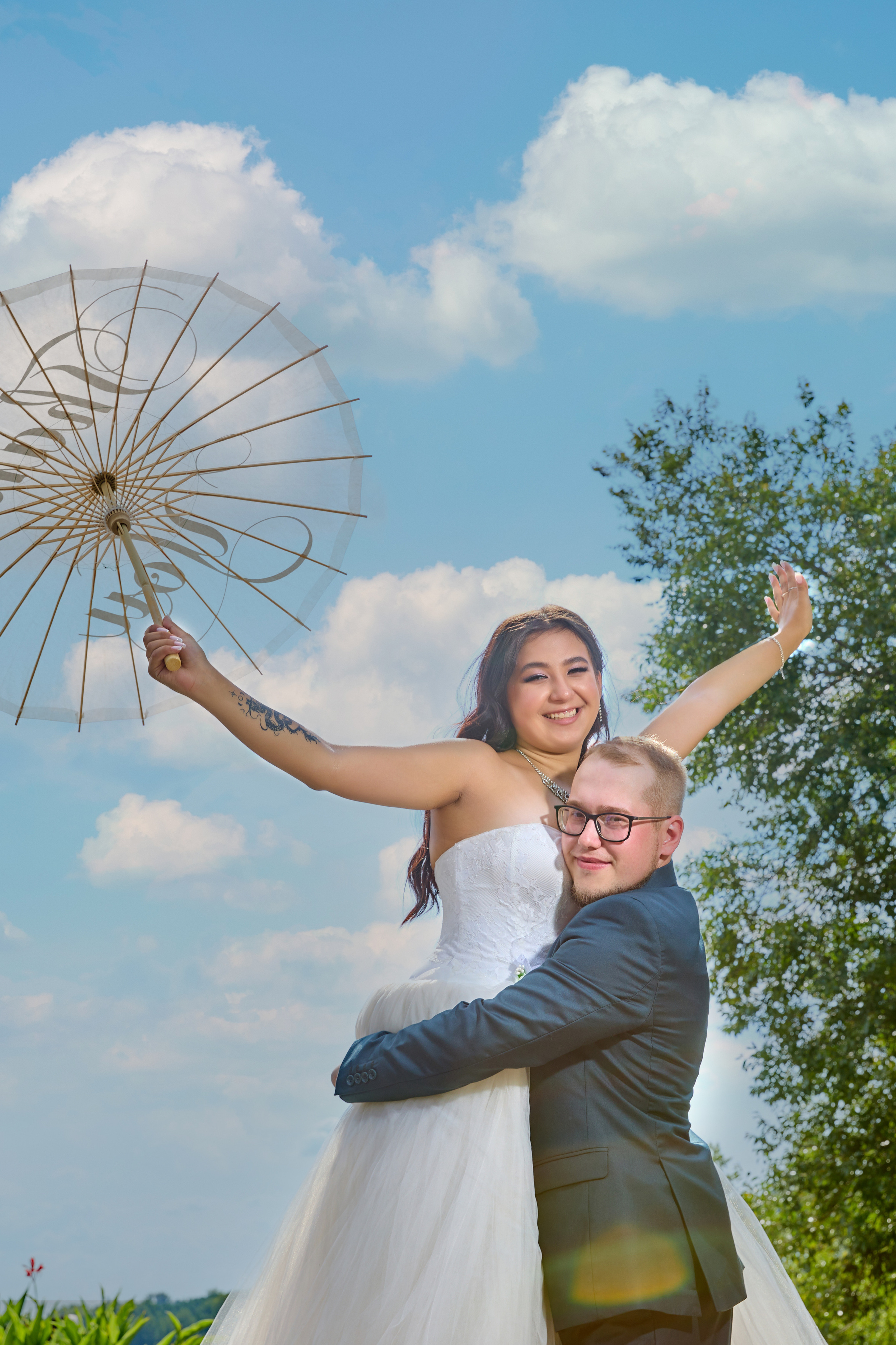 Жених поднял невесту на руки , которая держит зонт