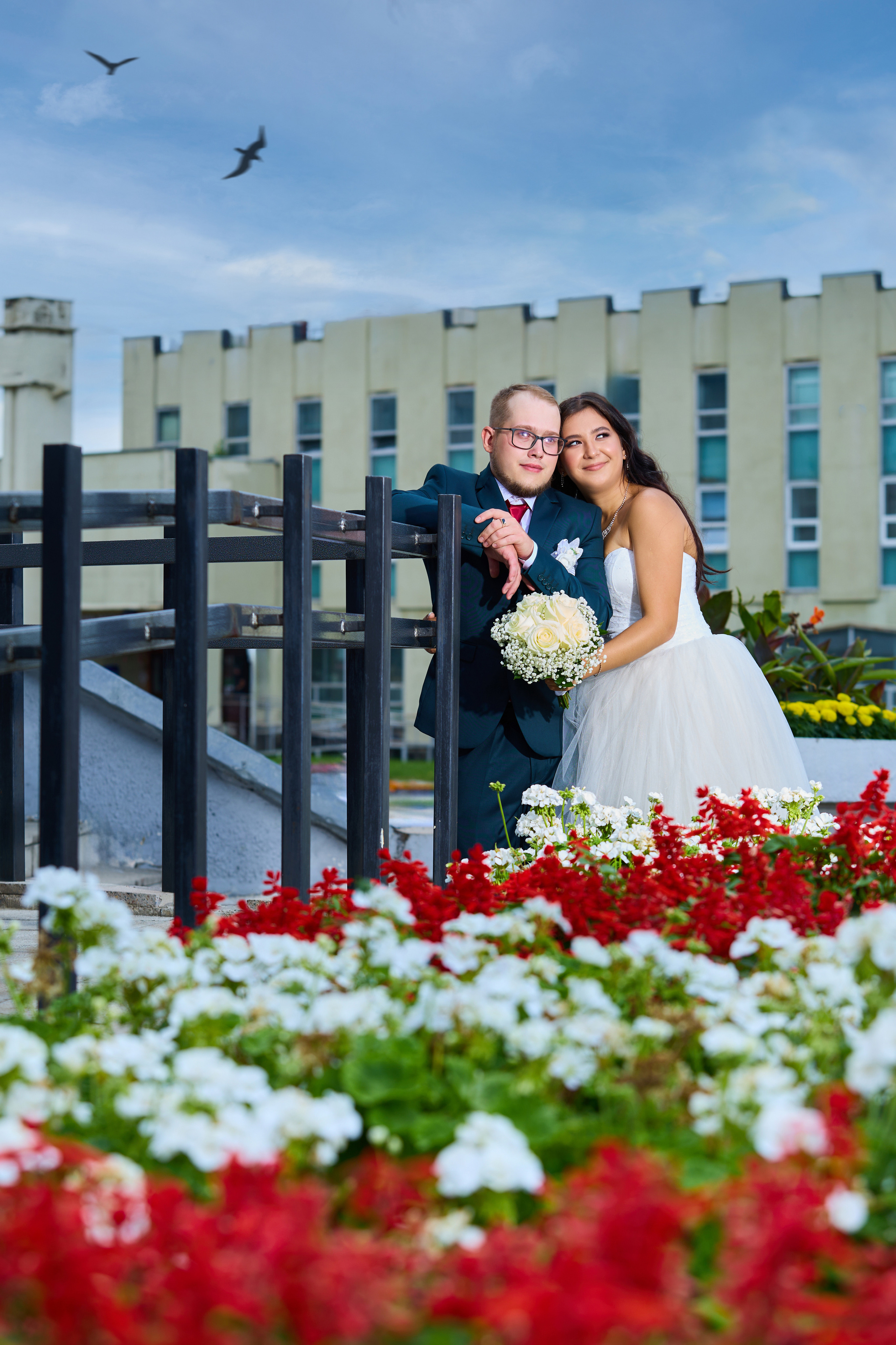 На входе в ЗАГС Железногорска жених. Невеста обнимает его. Цветы