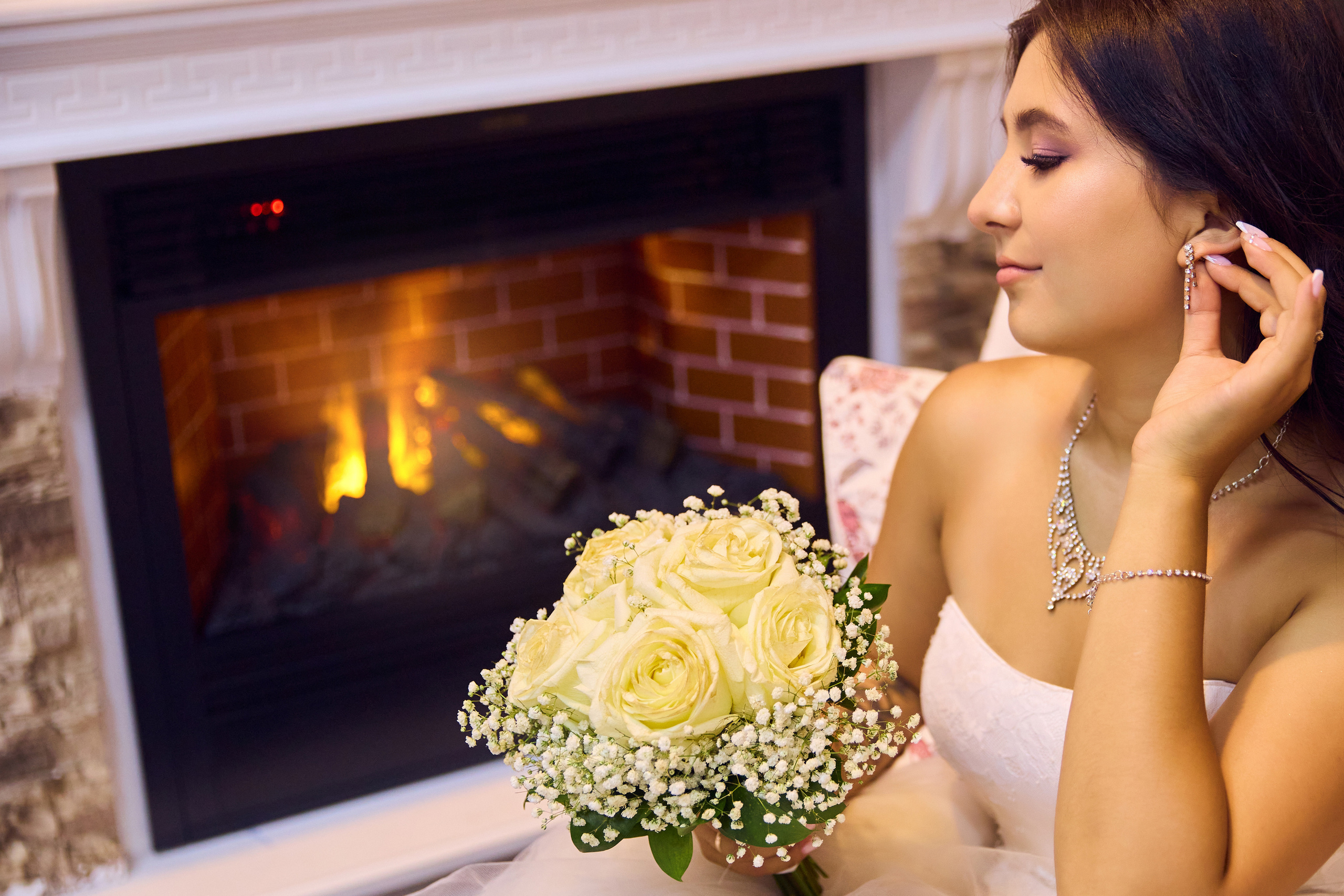 Невеста поправляет серёжку у камина