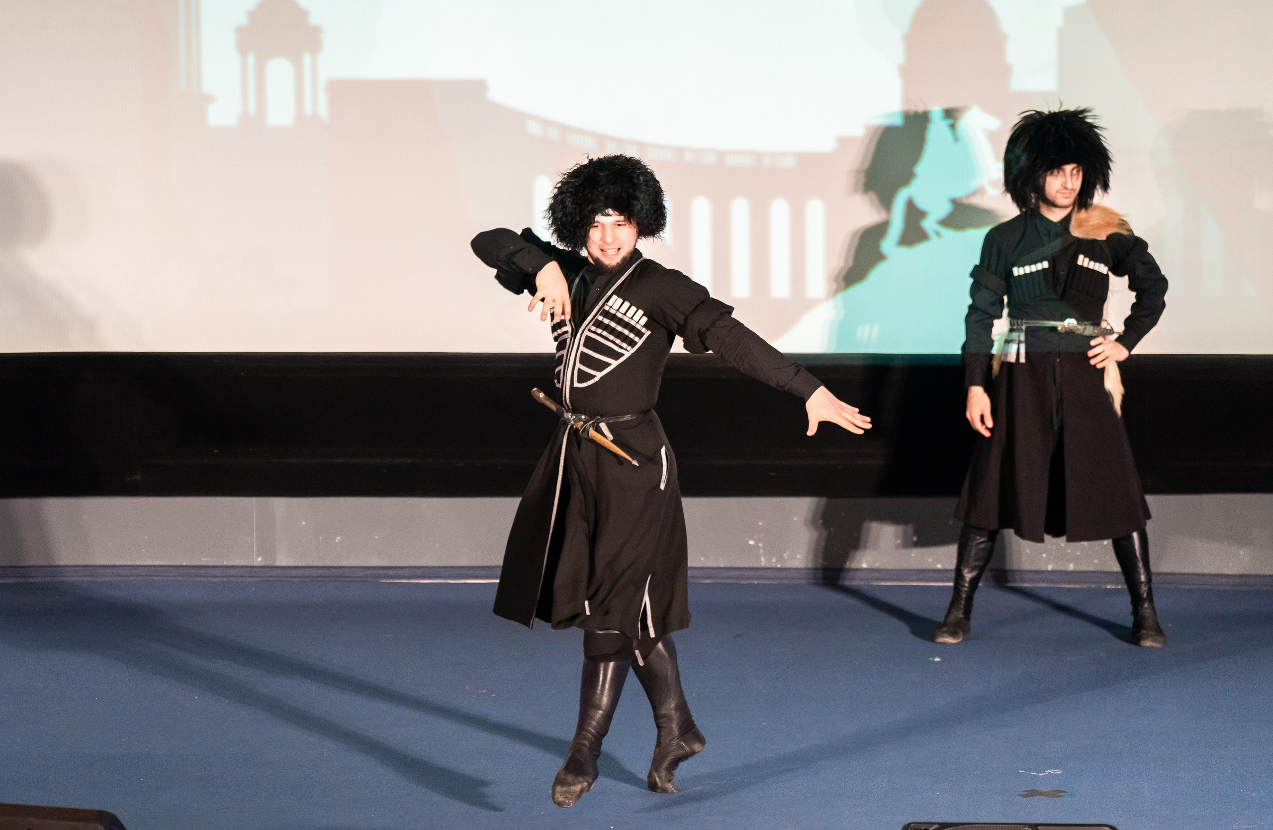 Два танцора в черных казачьих костюмах и папахах исполняют энергичный танец на фестивале «Сохраняем традиции». Санкт-Петербург, 2026. Фото: Мальцев Евгений.
