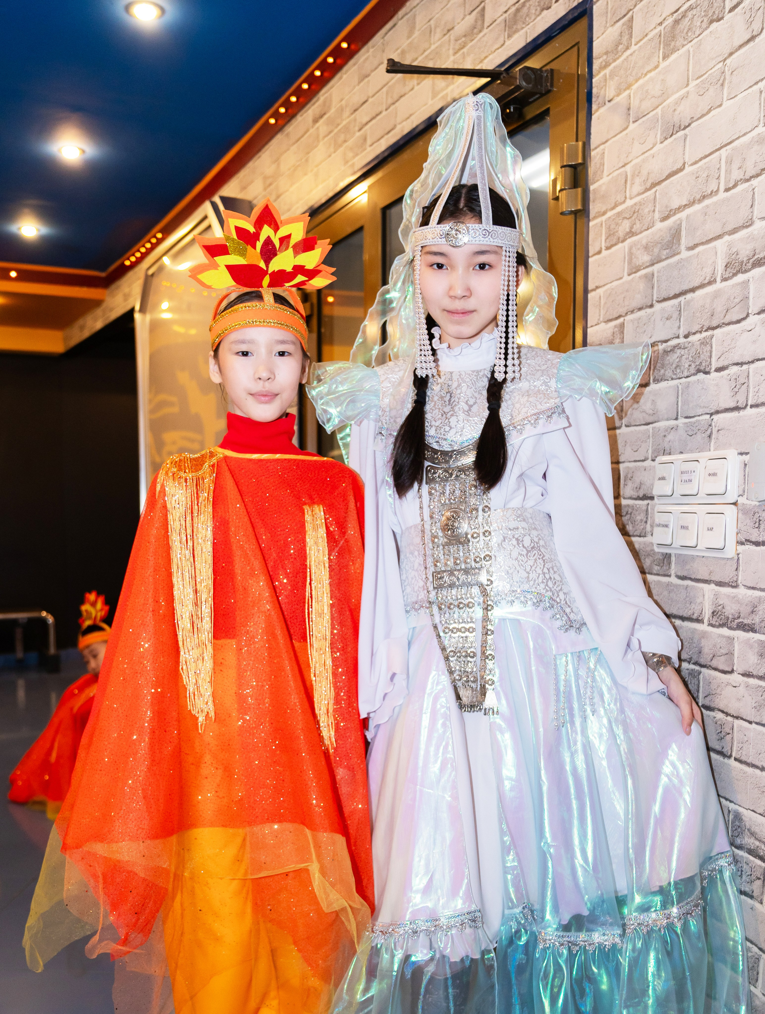  Две девочки в ярких национальных костюмах (красный и белый) на XII Международном фольклорном фестивале «Сохраняем традиции» Санкт-Петербург 2026. Фото: Мальцев Евгений, evrednix.ru.