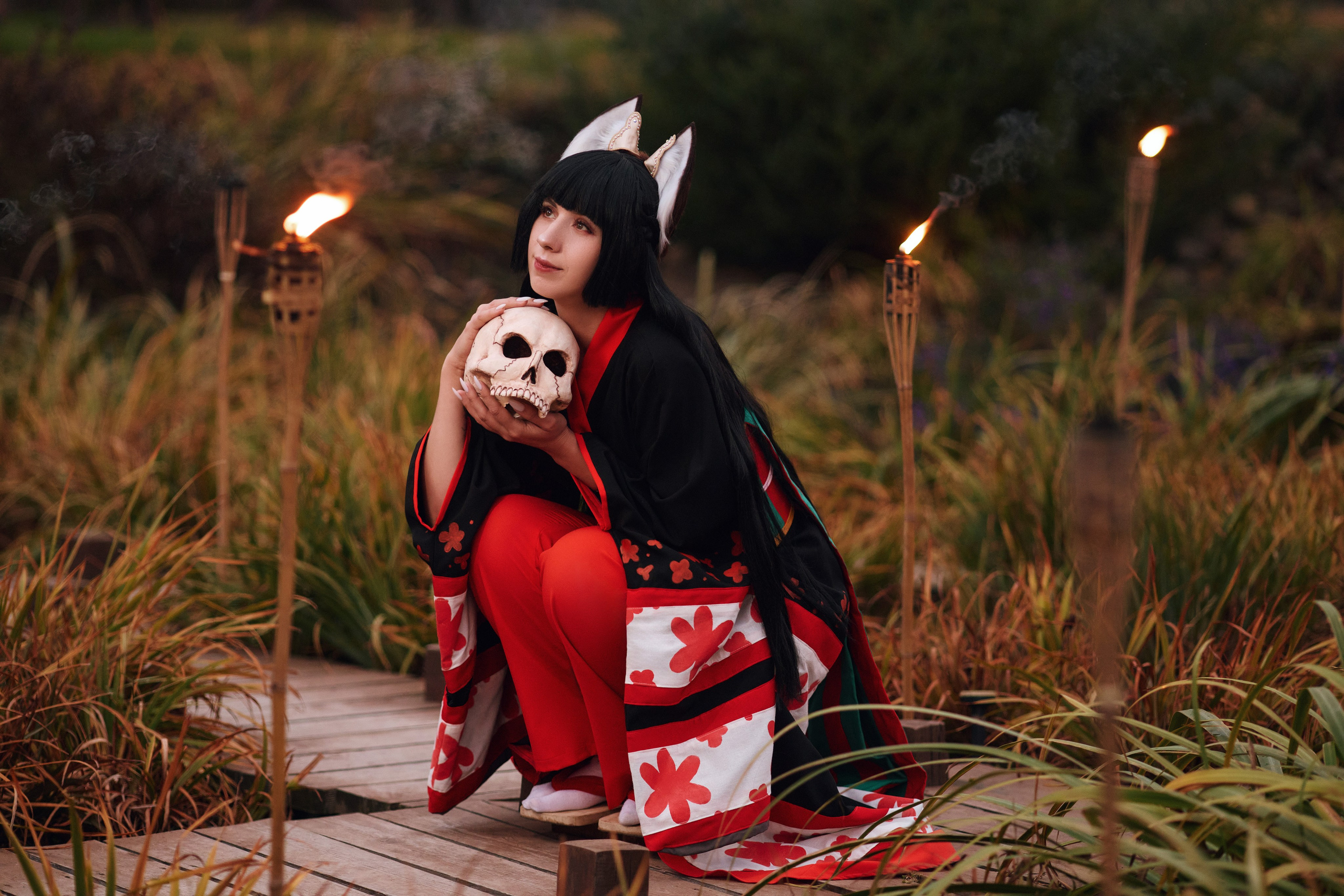 Косплей фотосессия после заката с девушкой в образе кицунэ, с черепом в руках и факелами на фоне