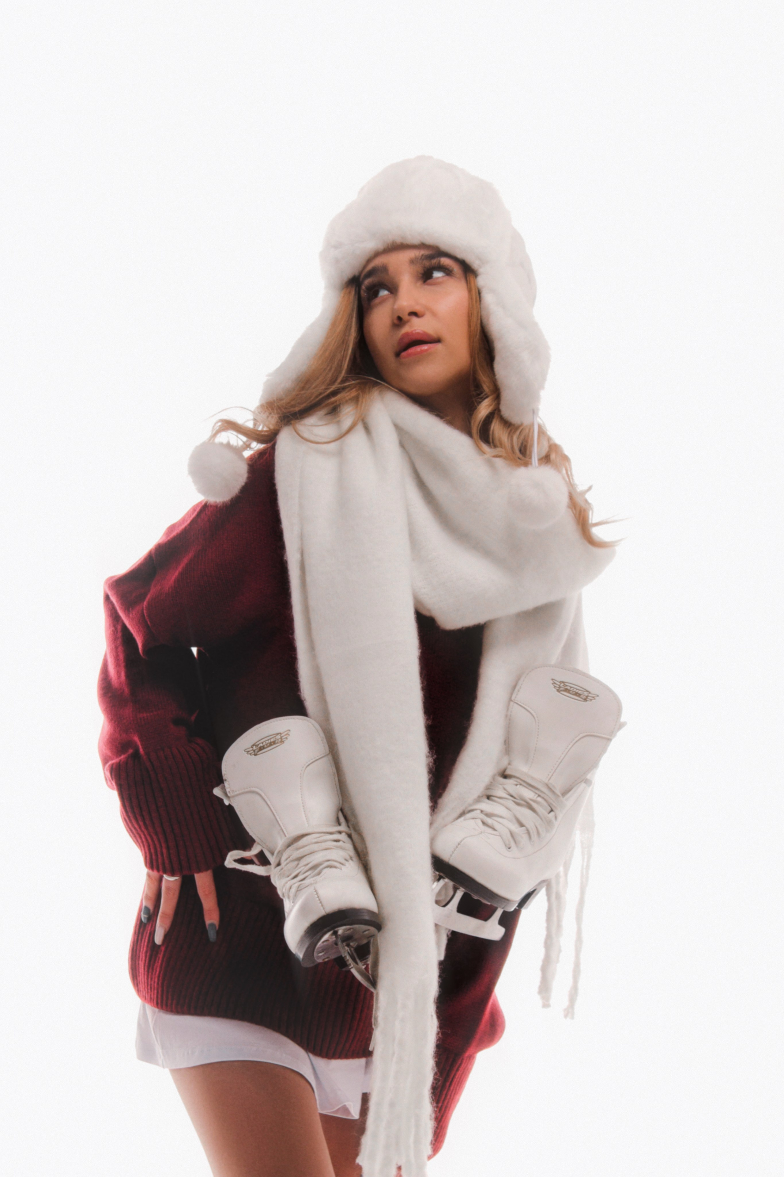 фотомодель в ушанке и коньках в студии