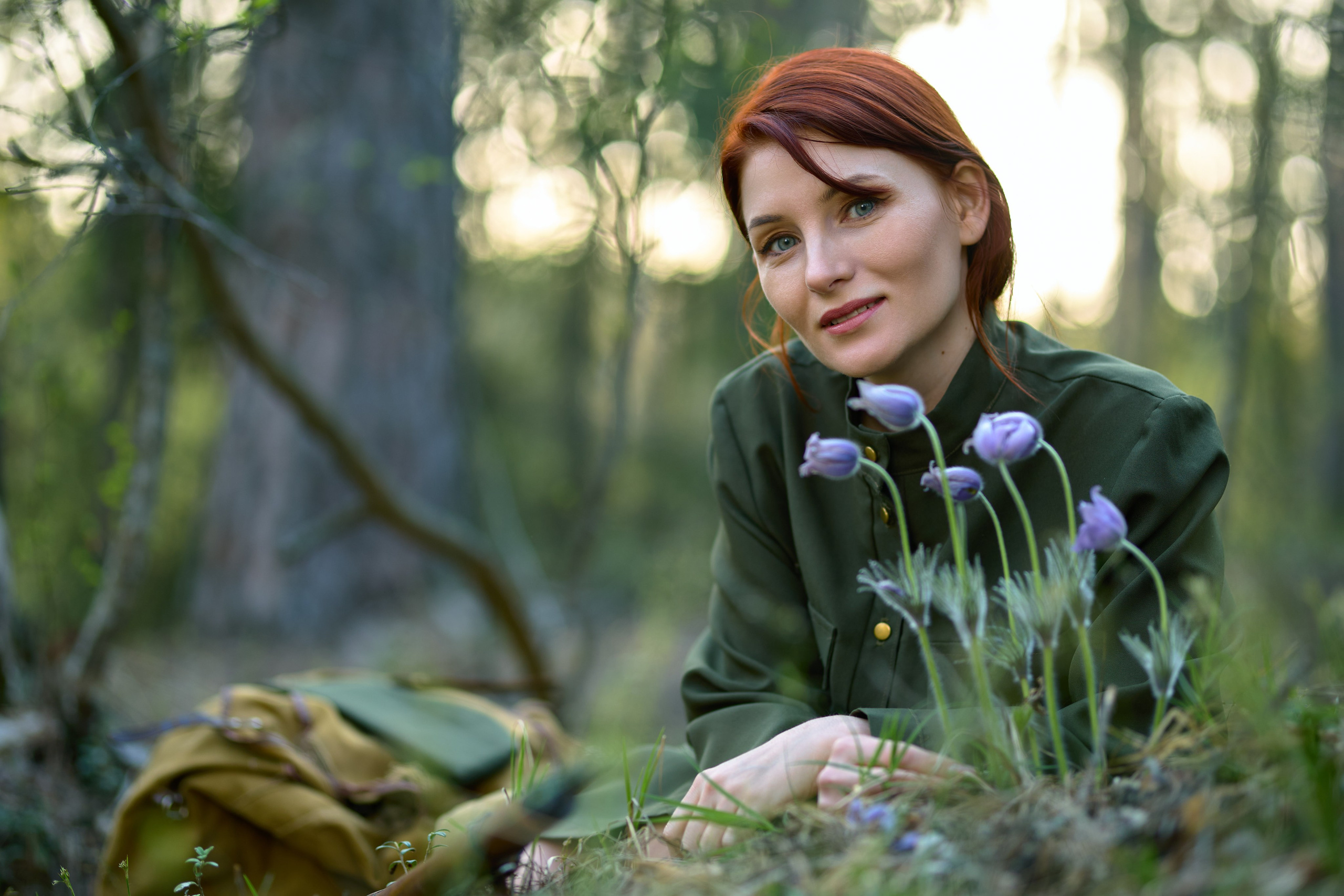 тематическая фотосессия на военную тему, девушка сидит с винтовкой в лесу около цветов