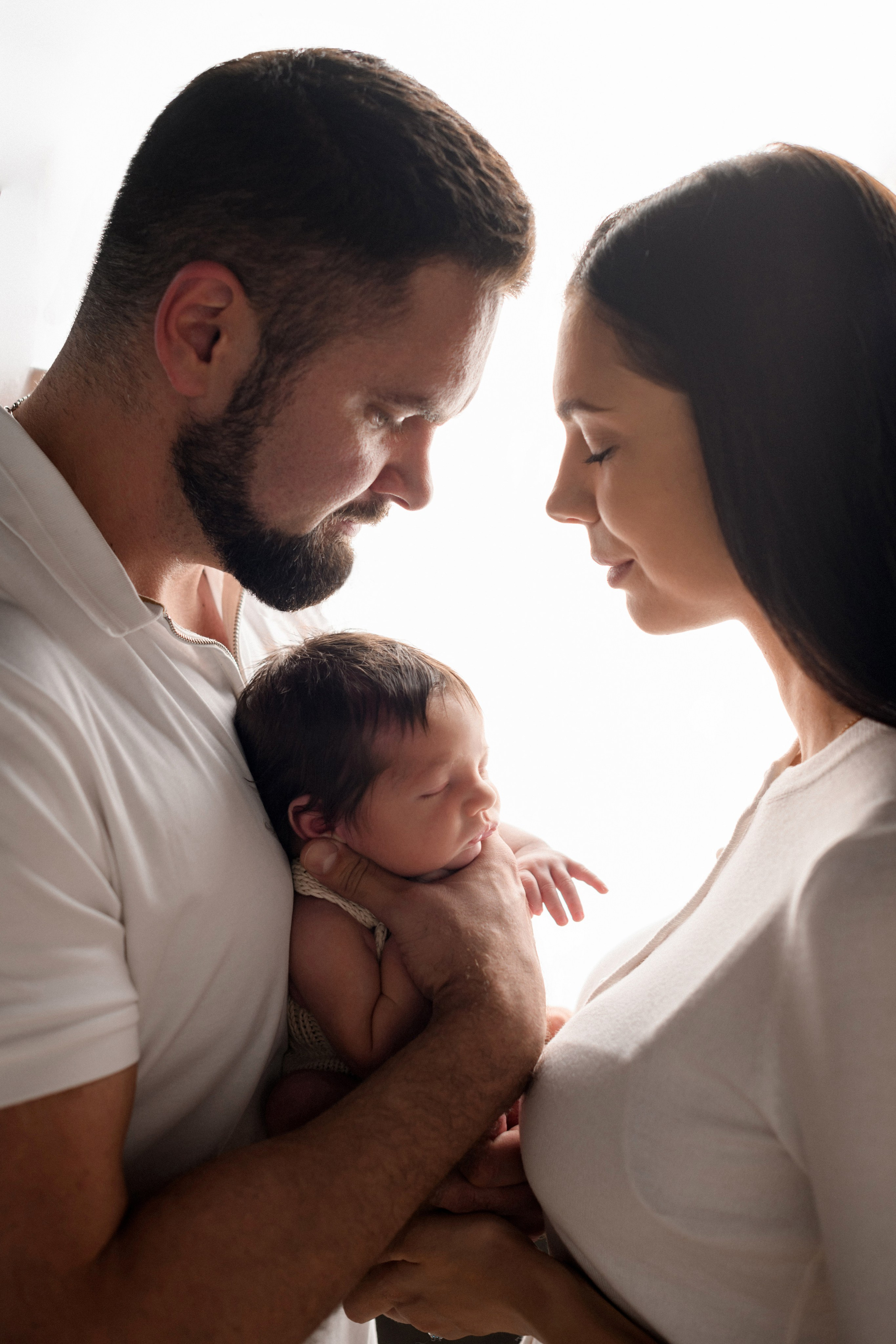 Родители с новорожденным малышом на белом фоне в newborn фотостудии "В капусте" фотографа Алёны Лариной в Липецке
