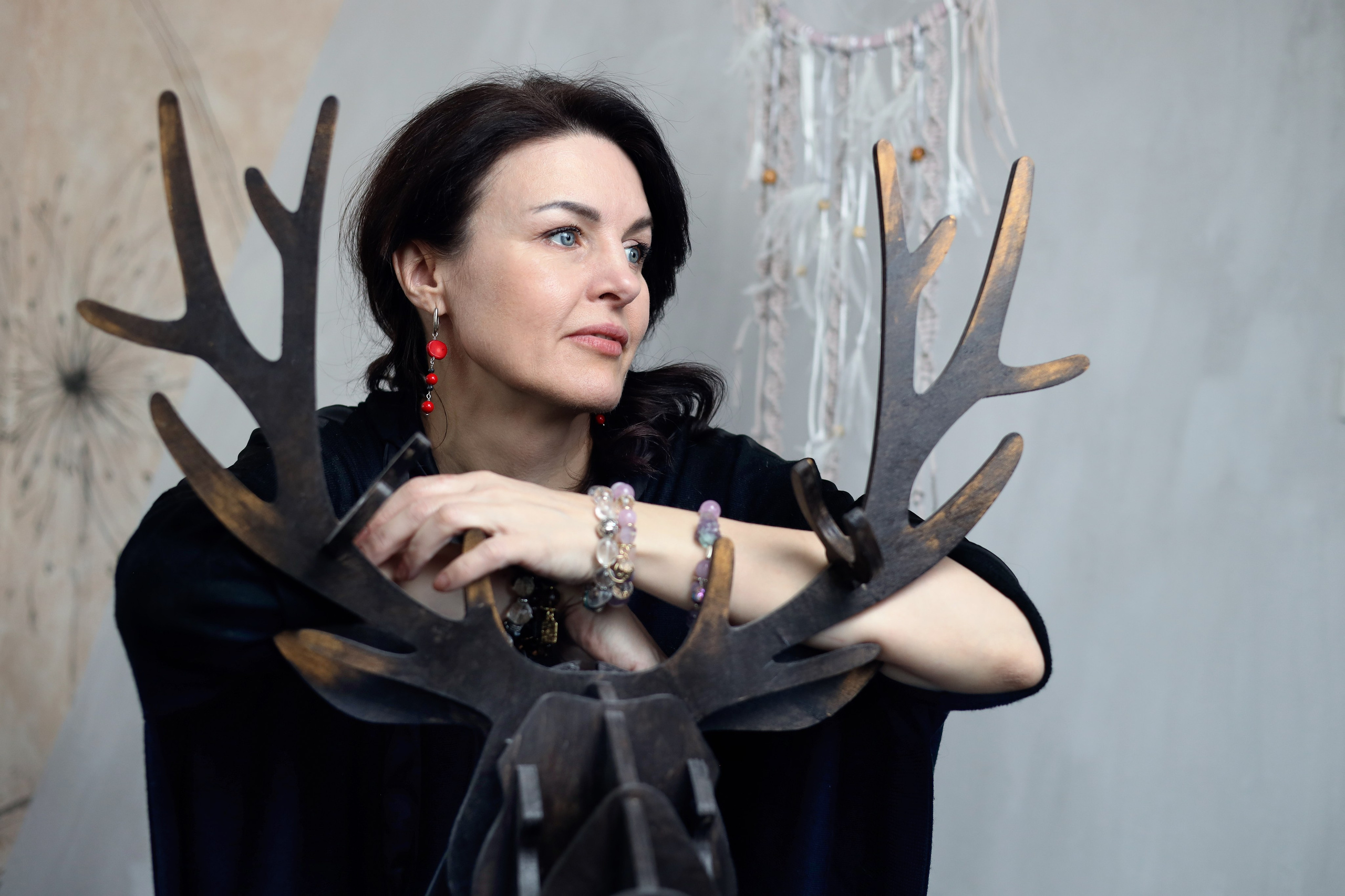 фотосессия в студии девушка смотрит в сторону и руки положила на оленя