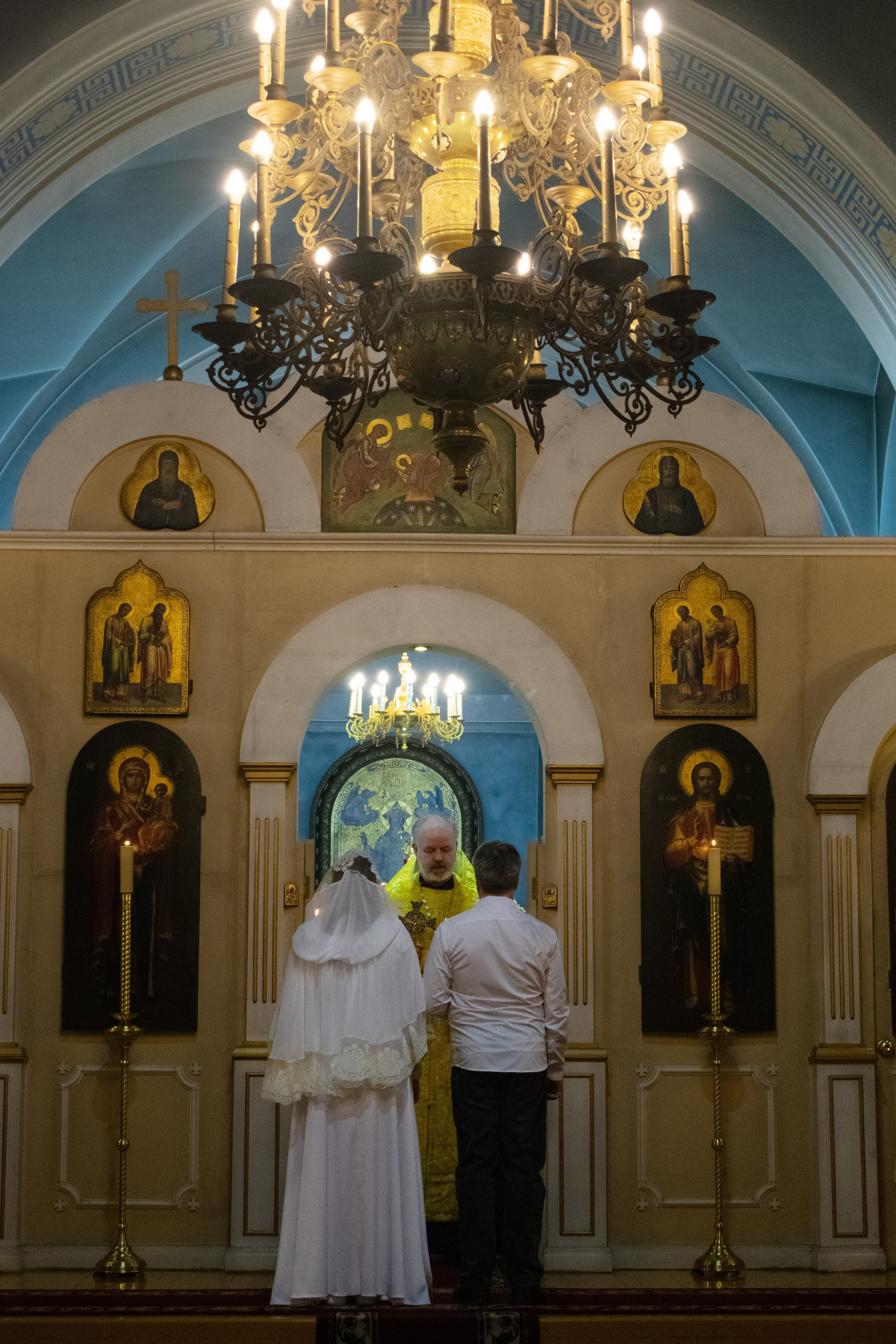 Фотосъемка церемонии венчания в никольском храме города Сортавала. Священник благословляет молодоженов.