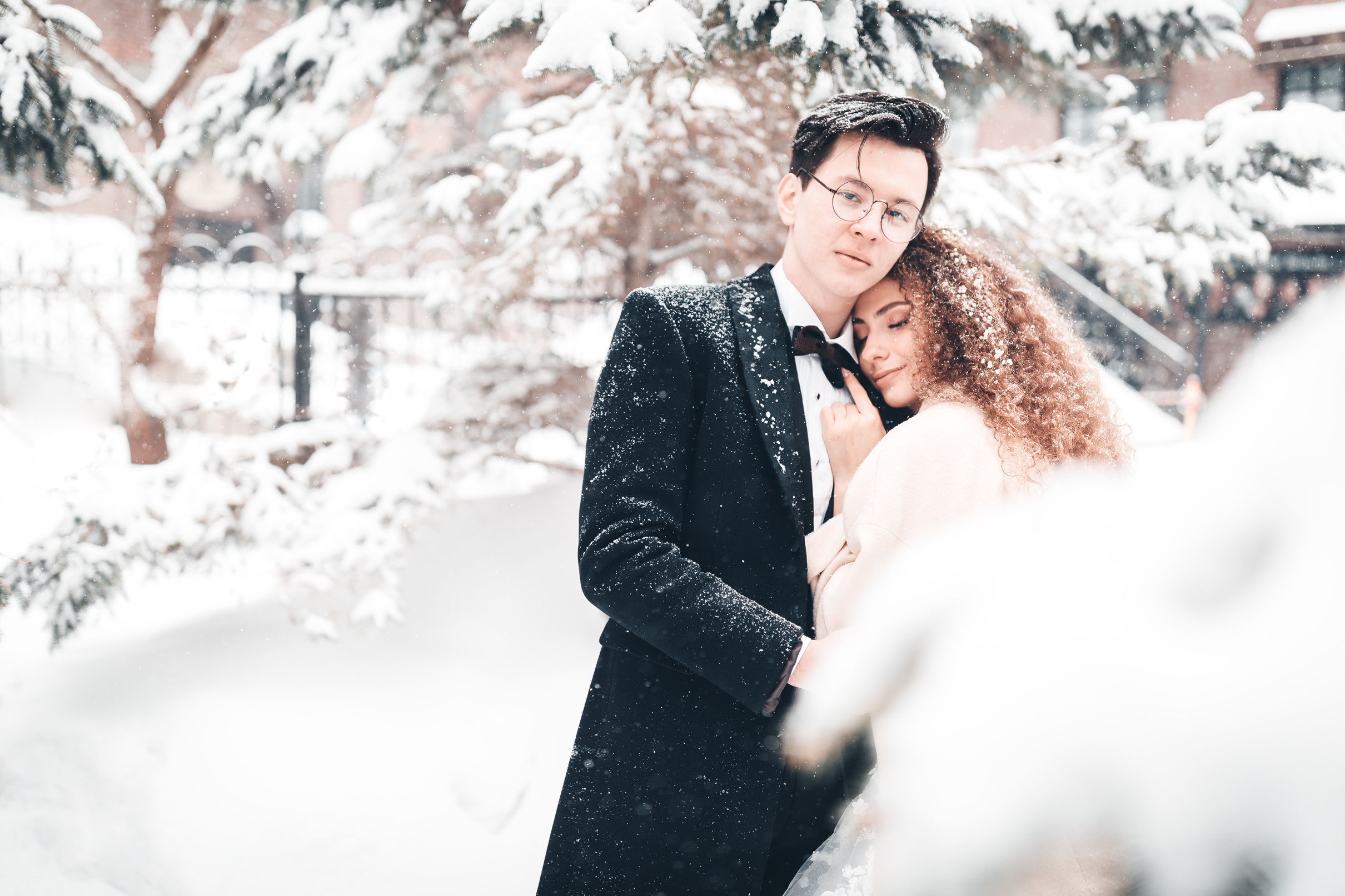 Жених и невеста обнимаются в зимнем парке