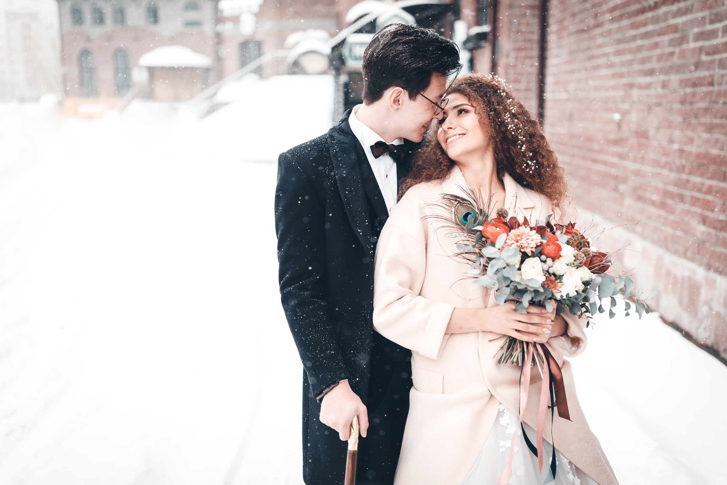 Жених и невеста смотрят друг другу в глаза в зимнем парке