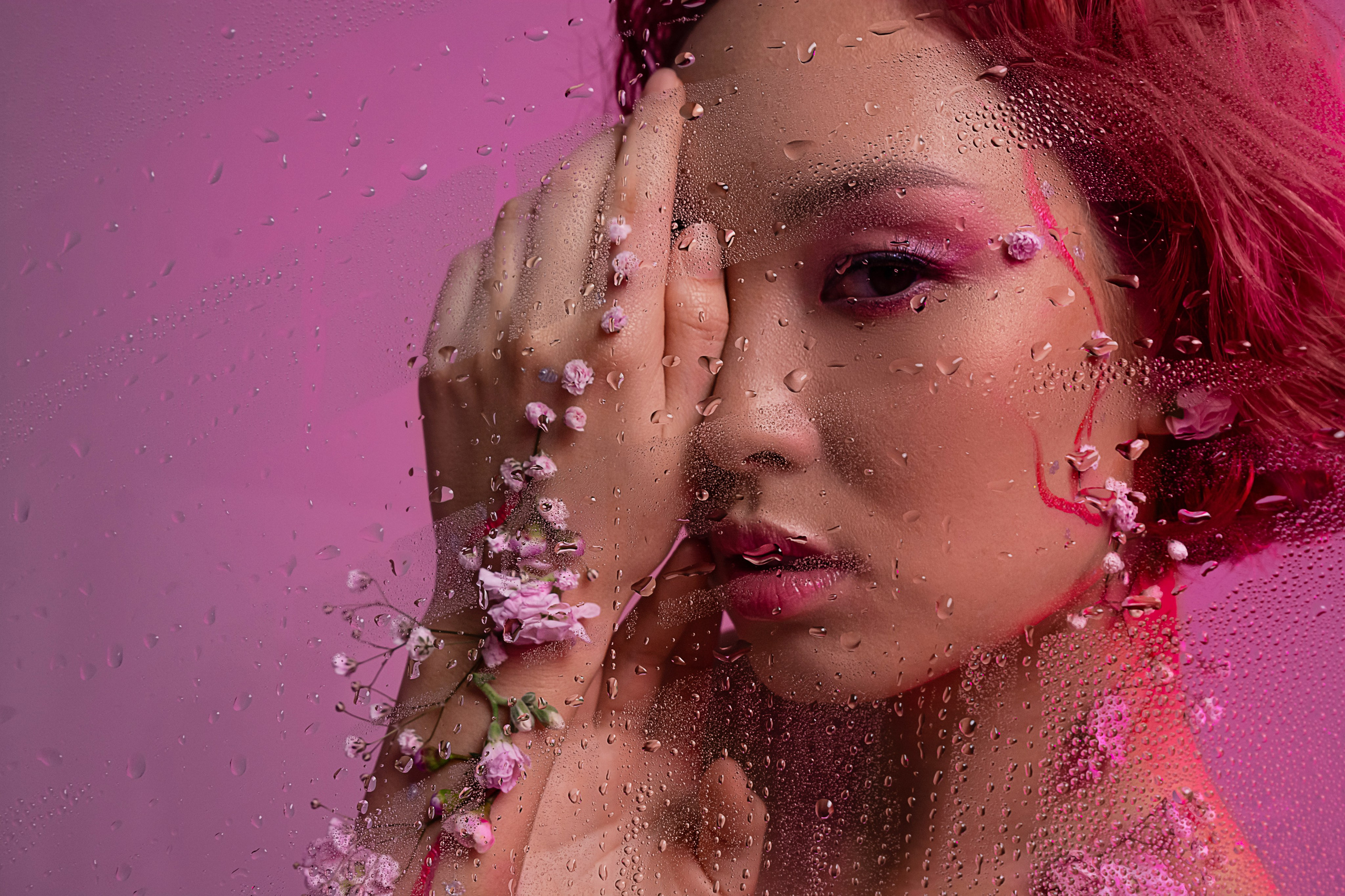  Загадочная азиатская красавица, декорированная весенними цветами, вглядывается сквозь замерзшее стекло, покрытое каплями, олицетворяя грядущее обновление.