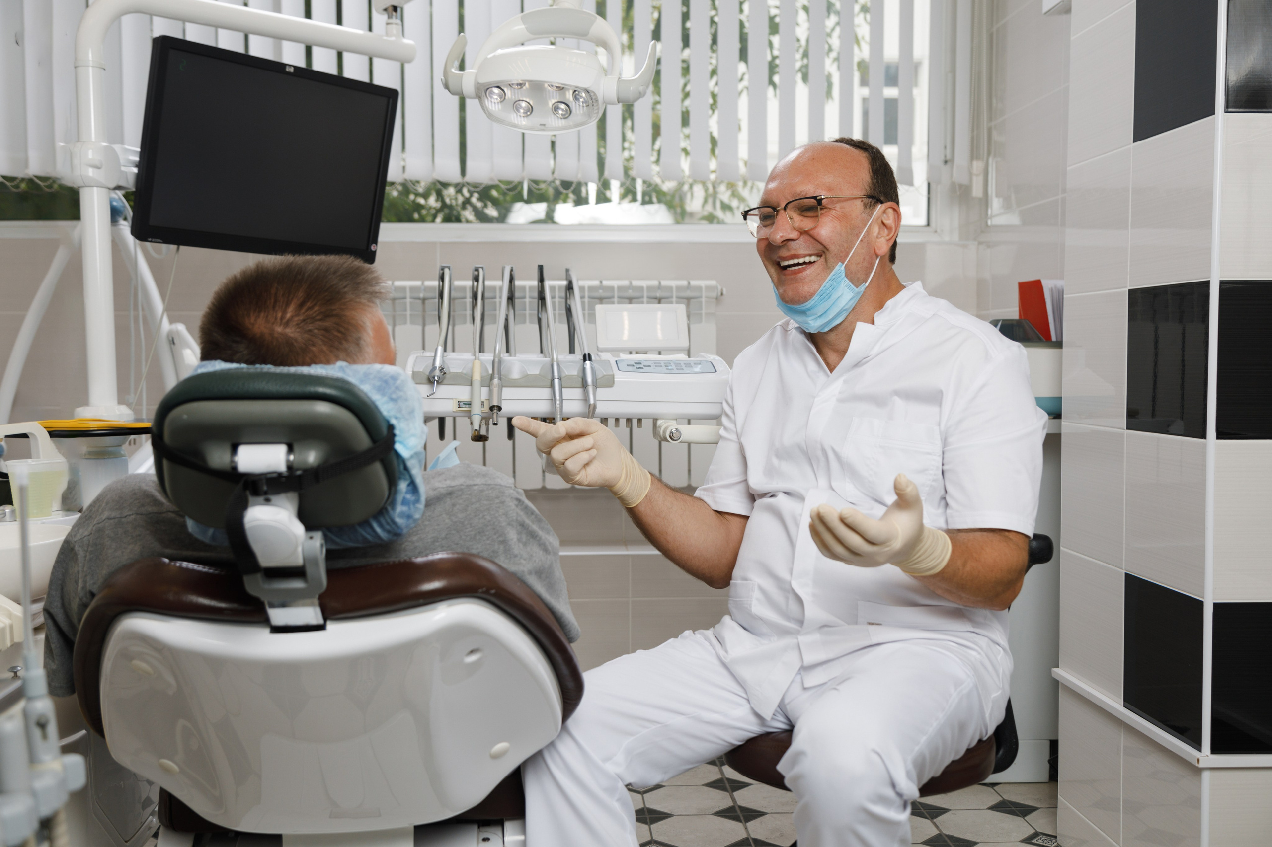 Врач-стоматолог консультирует пациента перед началом лечения. Доверительная беседа в клинике.