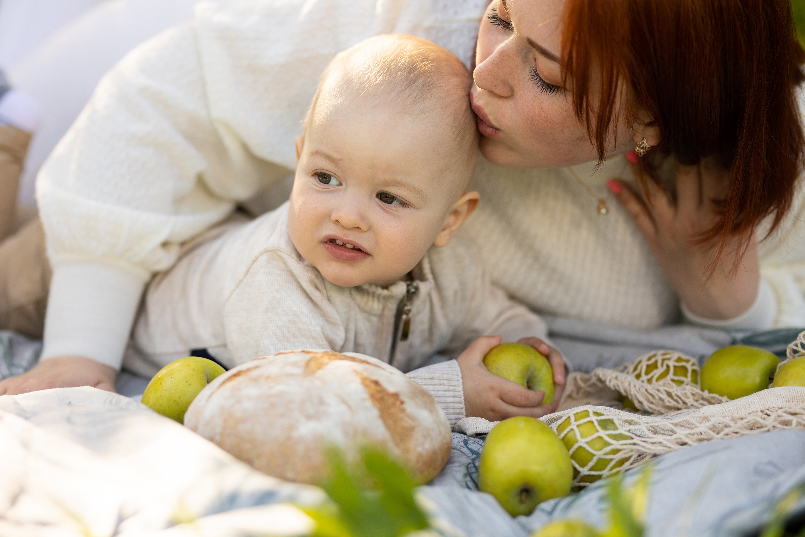 мама нежно целует малыша