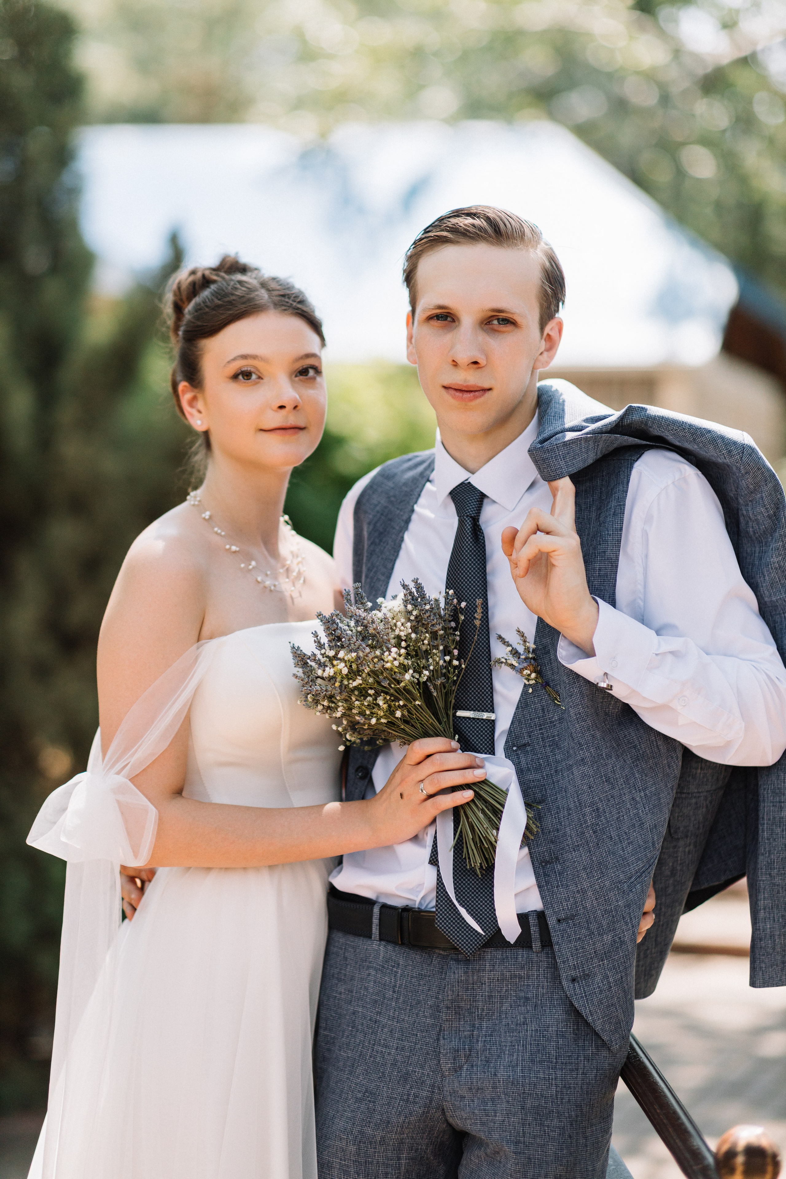 Пара гуляет по саду после церемонии, держась за руки.