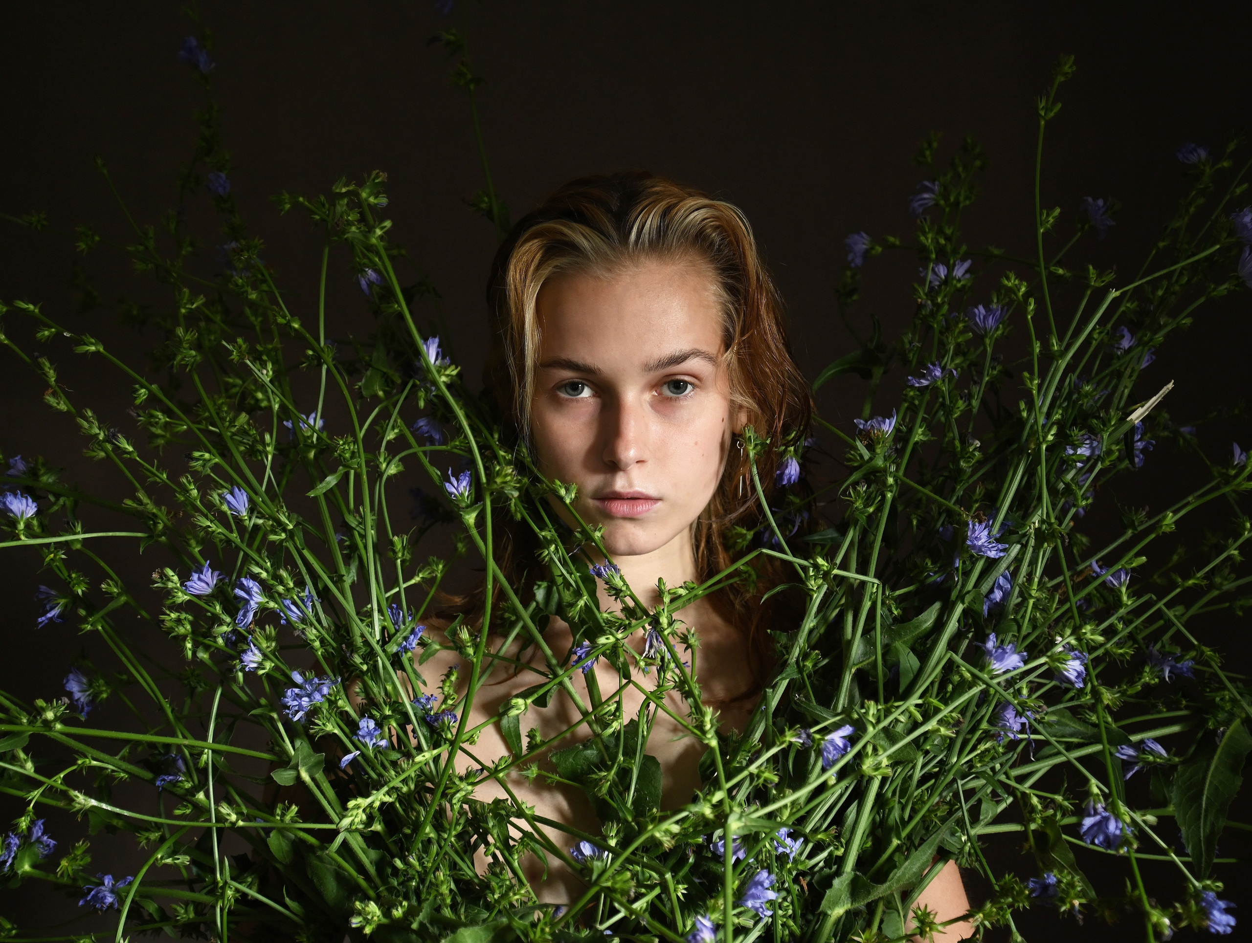 Голубые цветы в руках у красивой девушки 