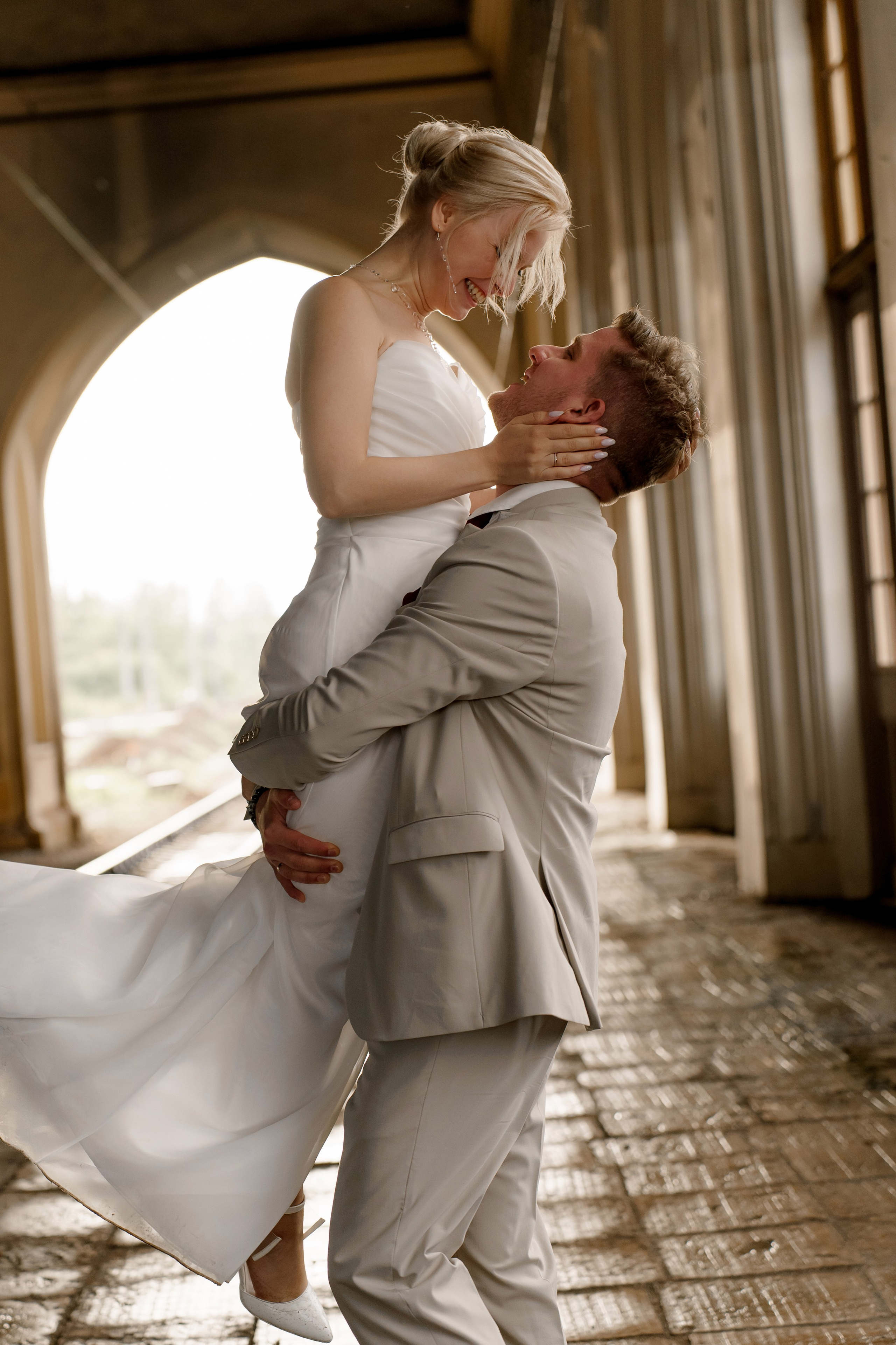 Свадьба в Санкт-Петербурге, фотосессия на прогулке, жених кружит невесту на руках на вокзале.