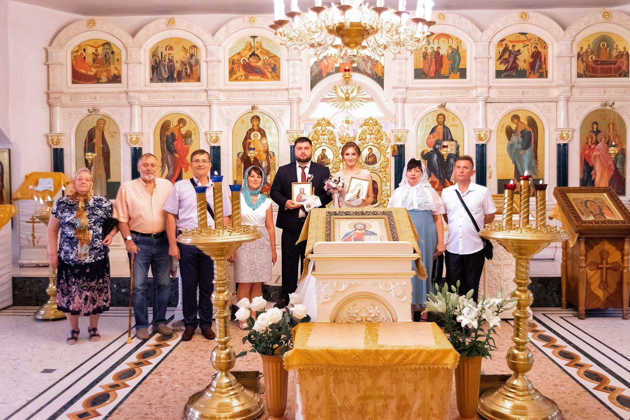 Фотосъемка в храме таинства венчания. Общее фото на фоне алтаря.