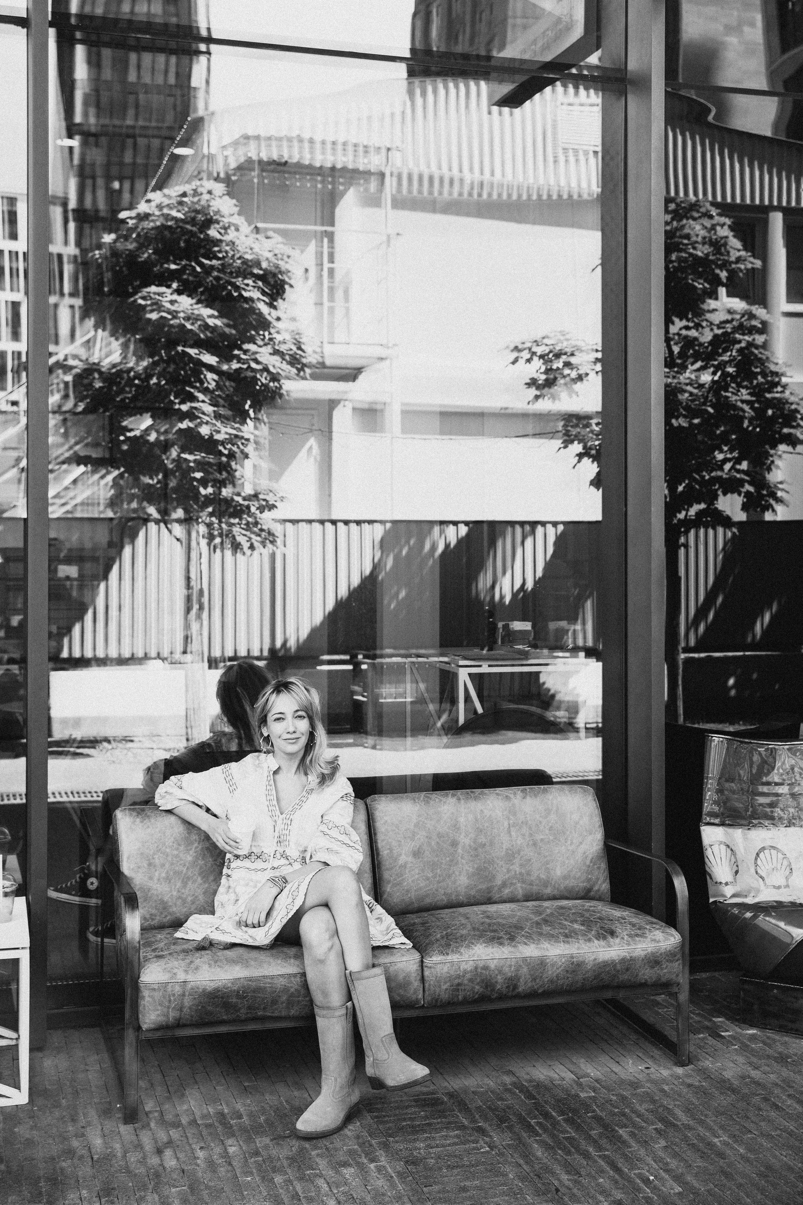 молодая мама в платье сидит и пьет кофе  в кафе на улице