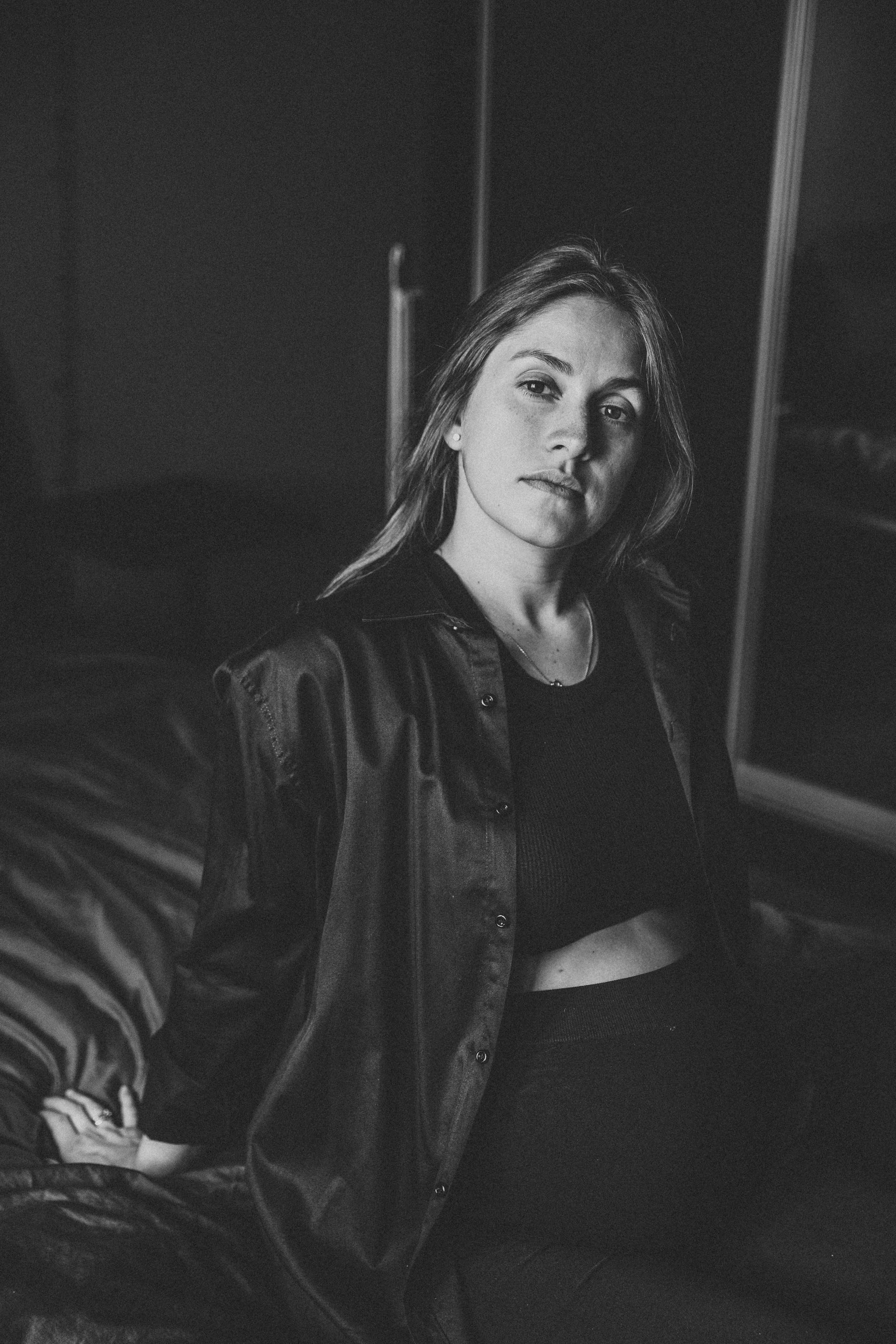 красивая беременная девушка в рубашки сидит на кровати у себя дома