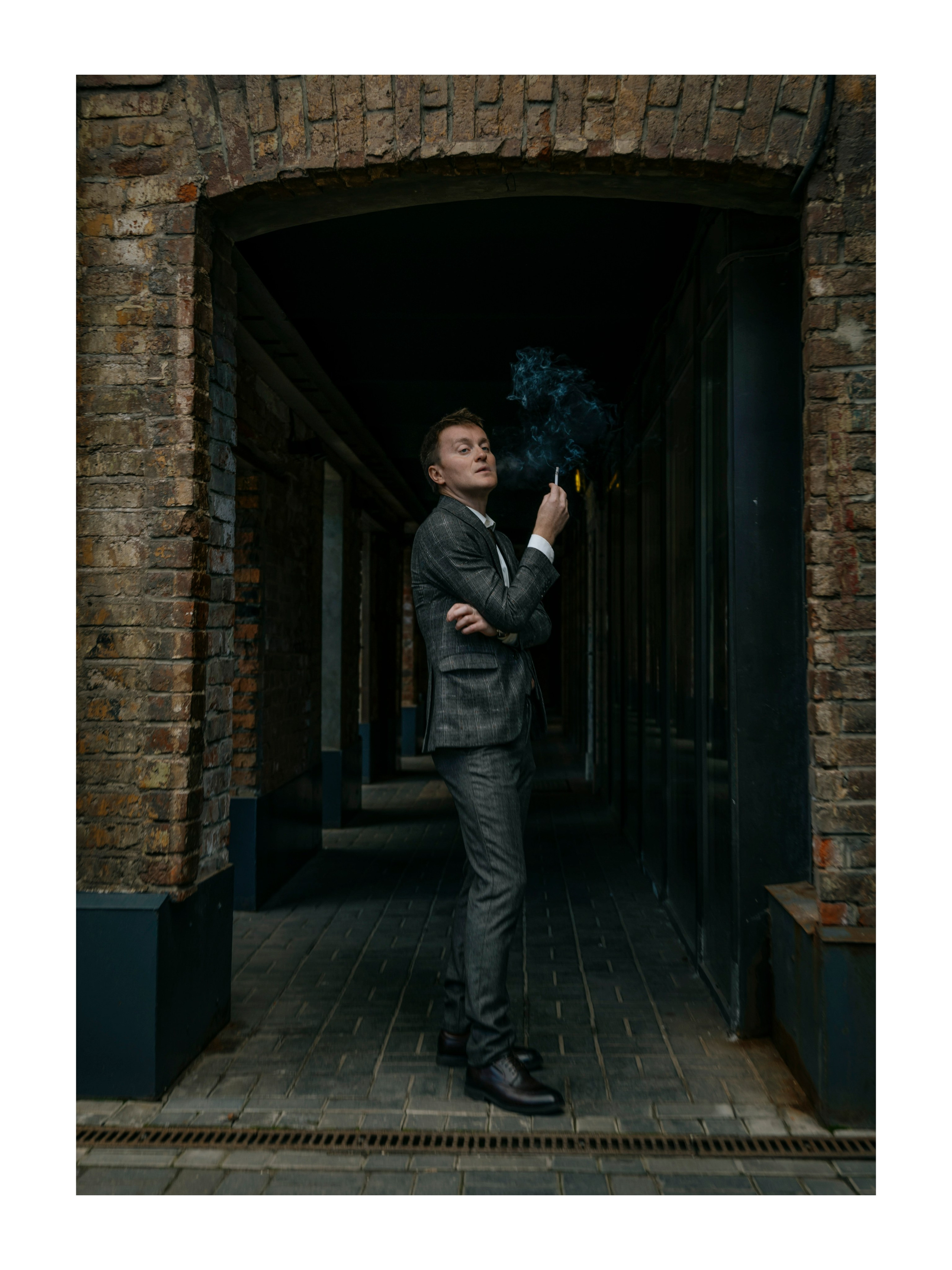 мужчина на фоне арки курит