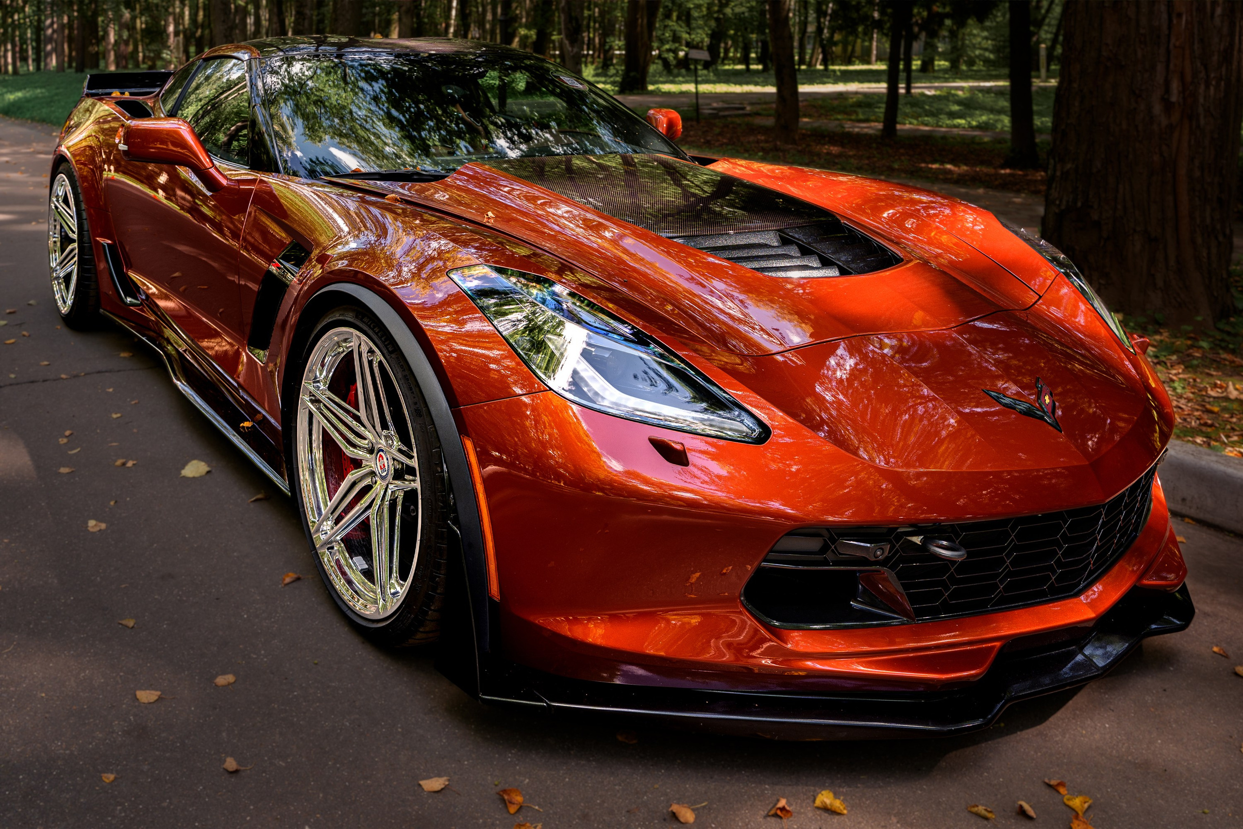Фотосъёмка Chevrolet Corvette C7 Z06: оранжевый спорткар крупным планом, кузов, фары и колёса.