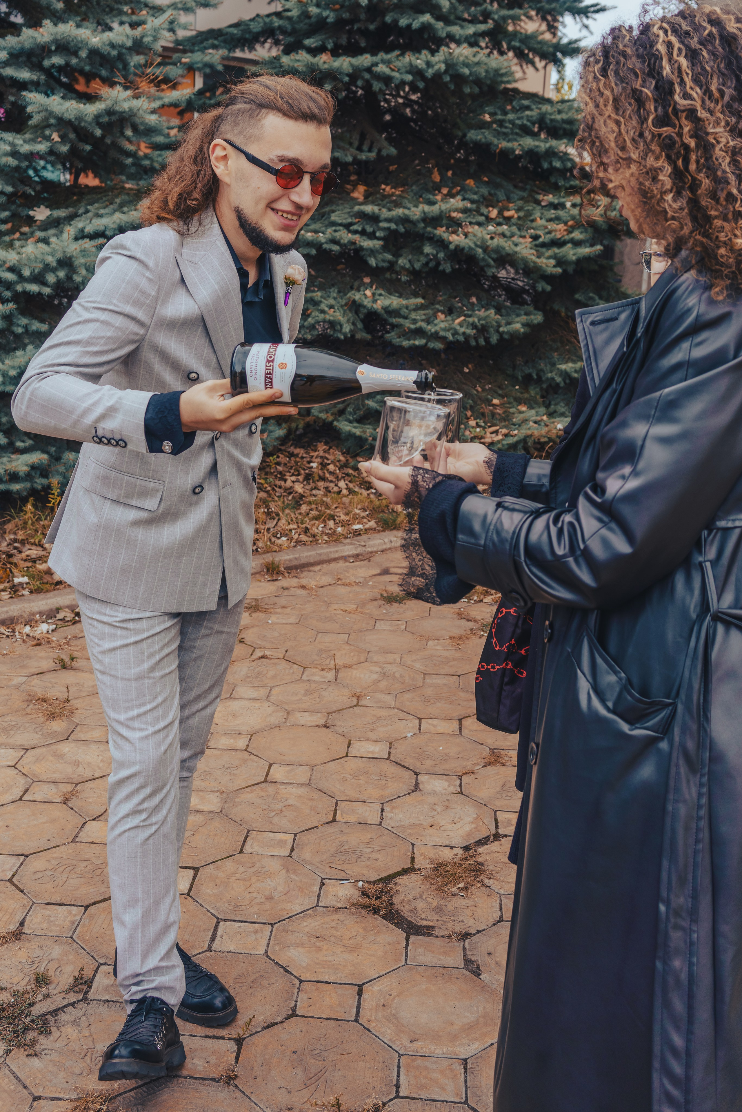 жених наливает шампанское в бокалы