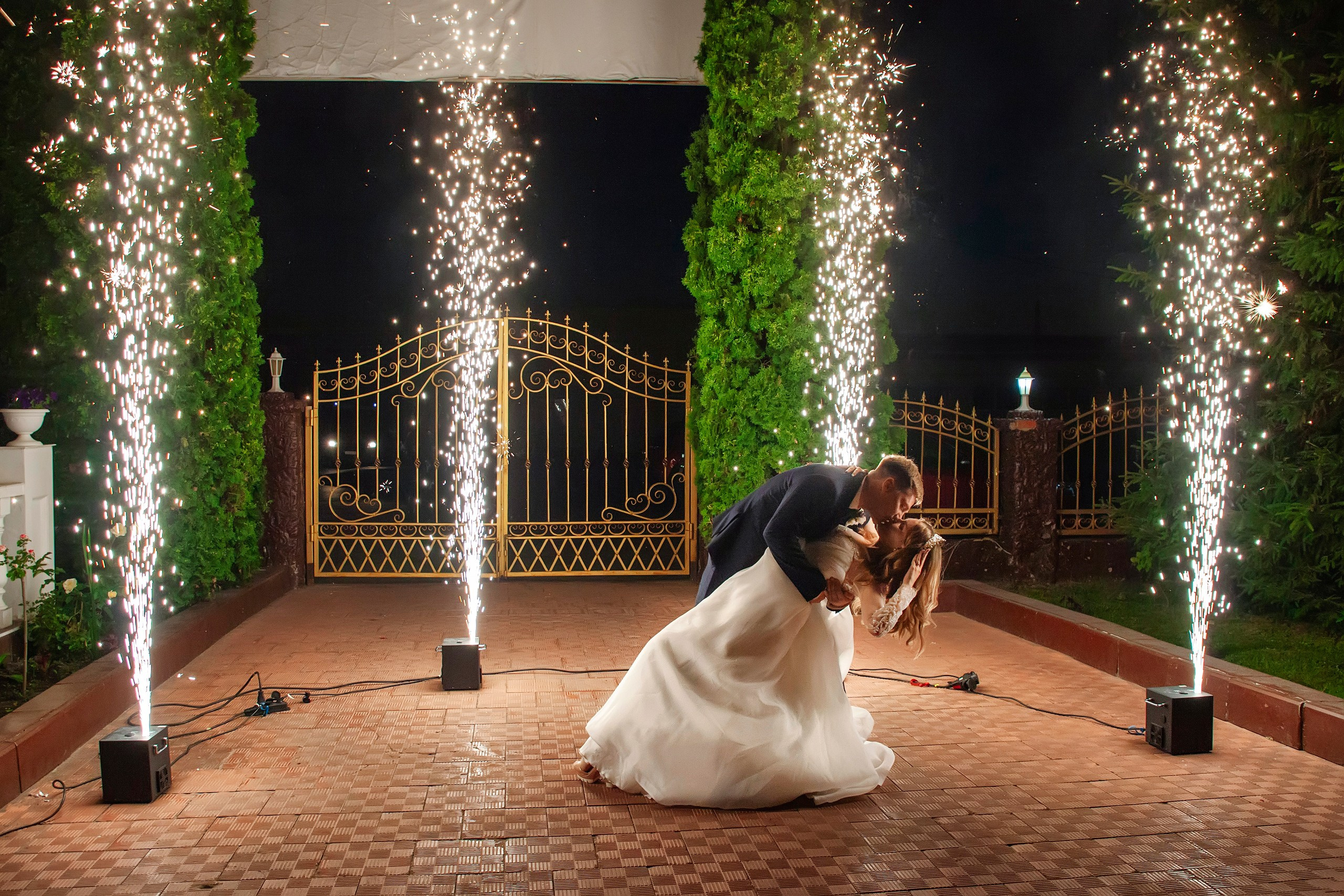 Жених целует невесту на фоне холодных фонтанов