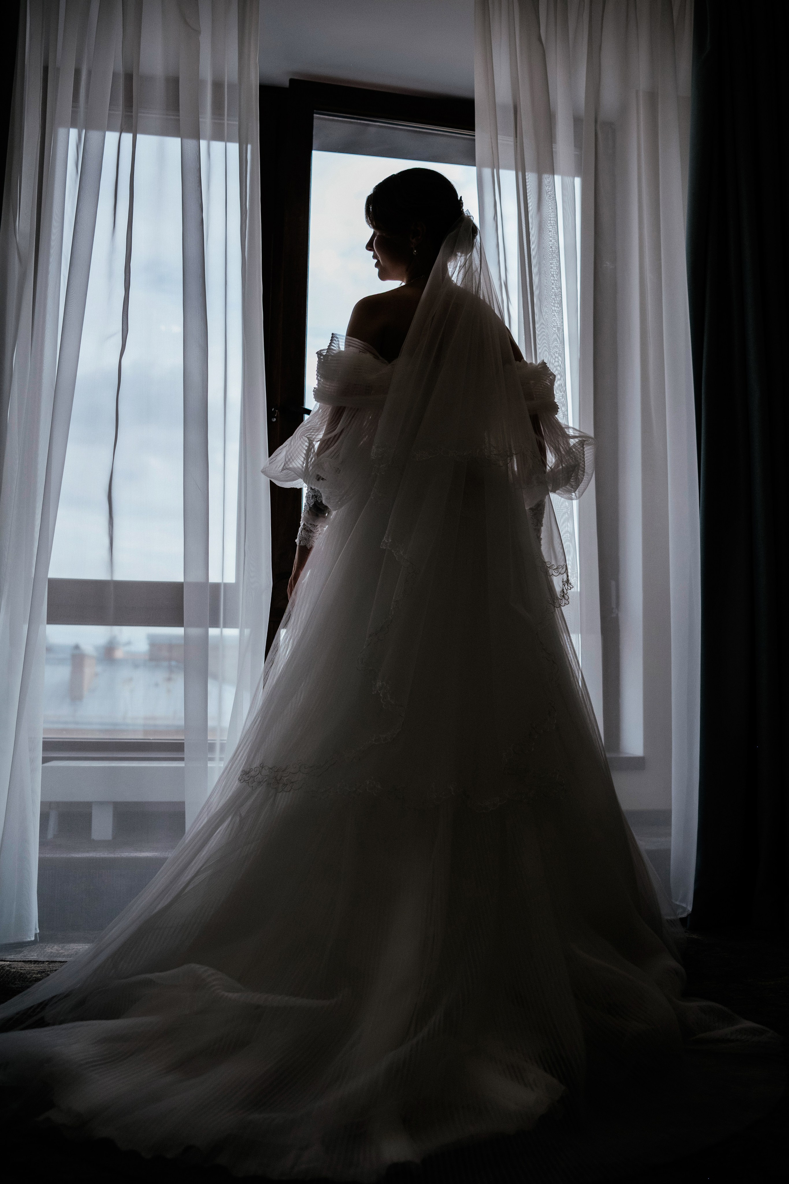 Силуэт невесты у окна — свадебное платье в пол