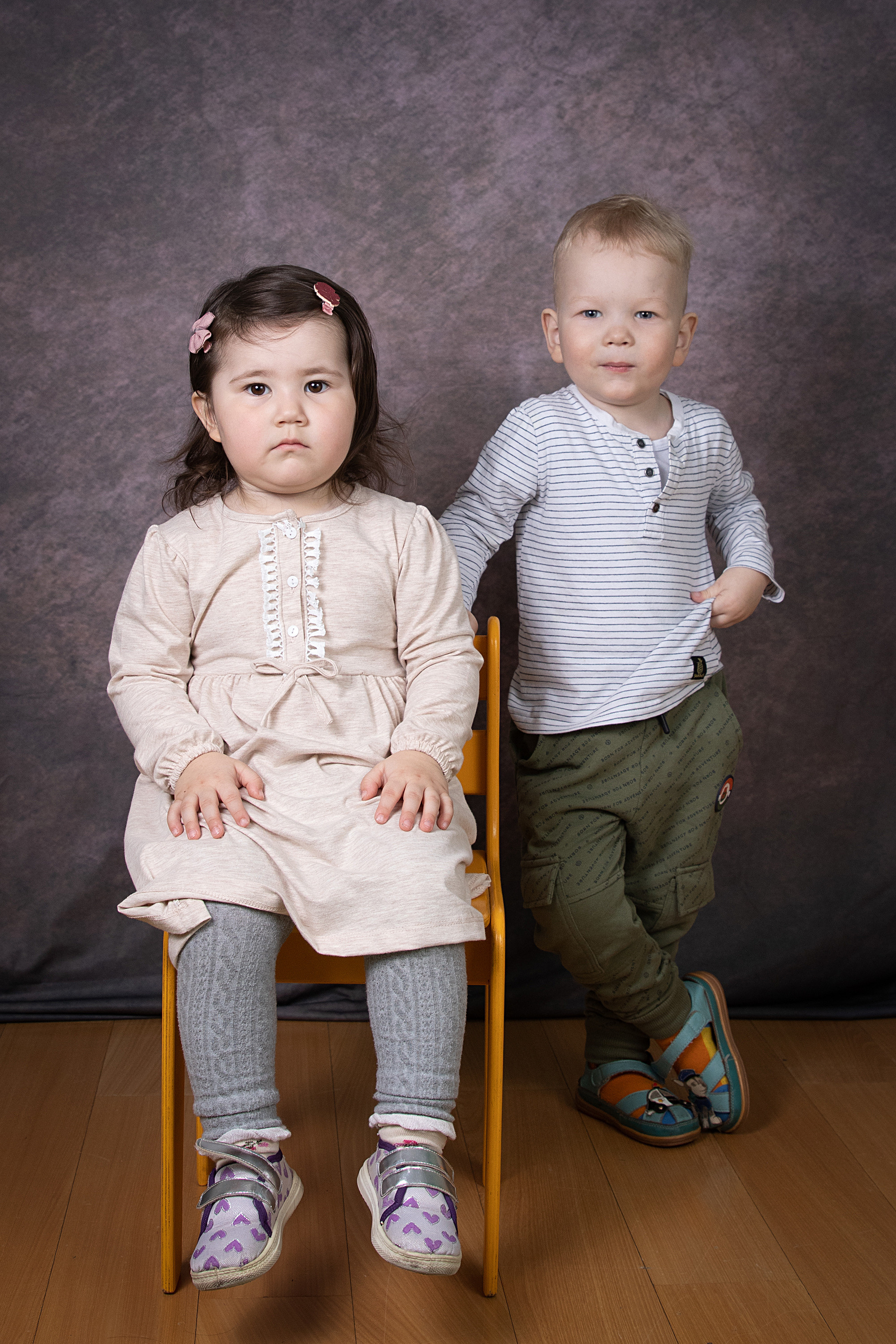 портрет маленькой девочки м мальчика в детском саду,  девочка сидит на стуле, а мальчик стоит рядом