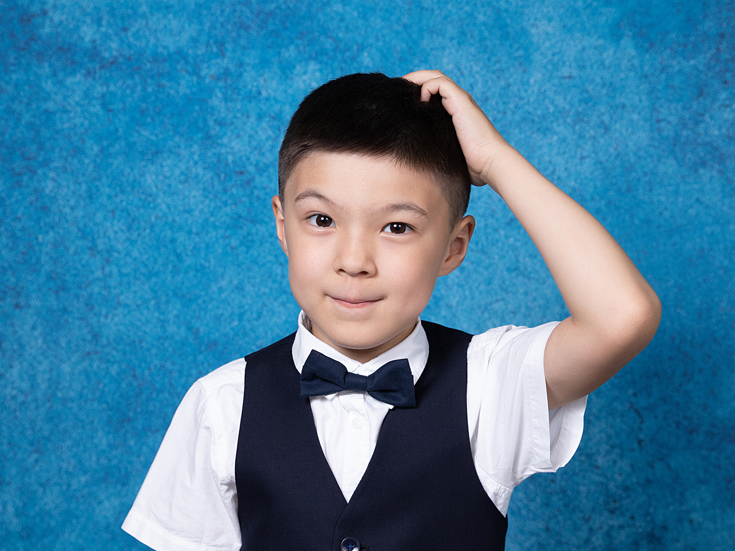 Мальчик - выпускник детского сада на голубом портретном фоне, эмоциональный портрет для виньетки в детском саду