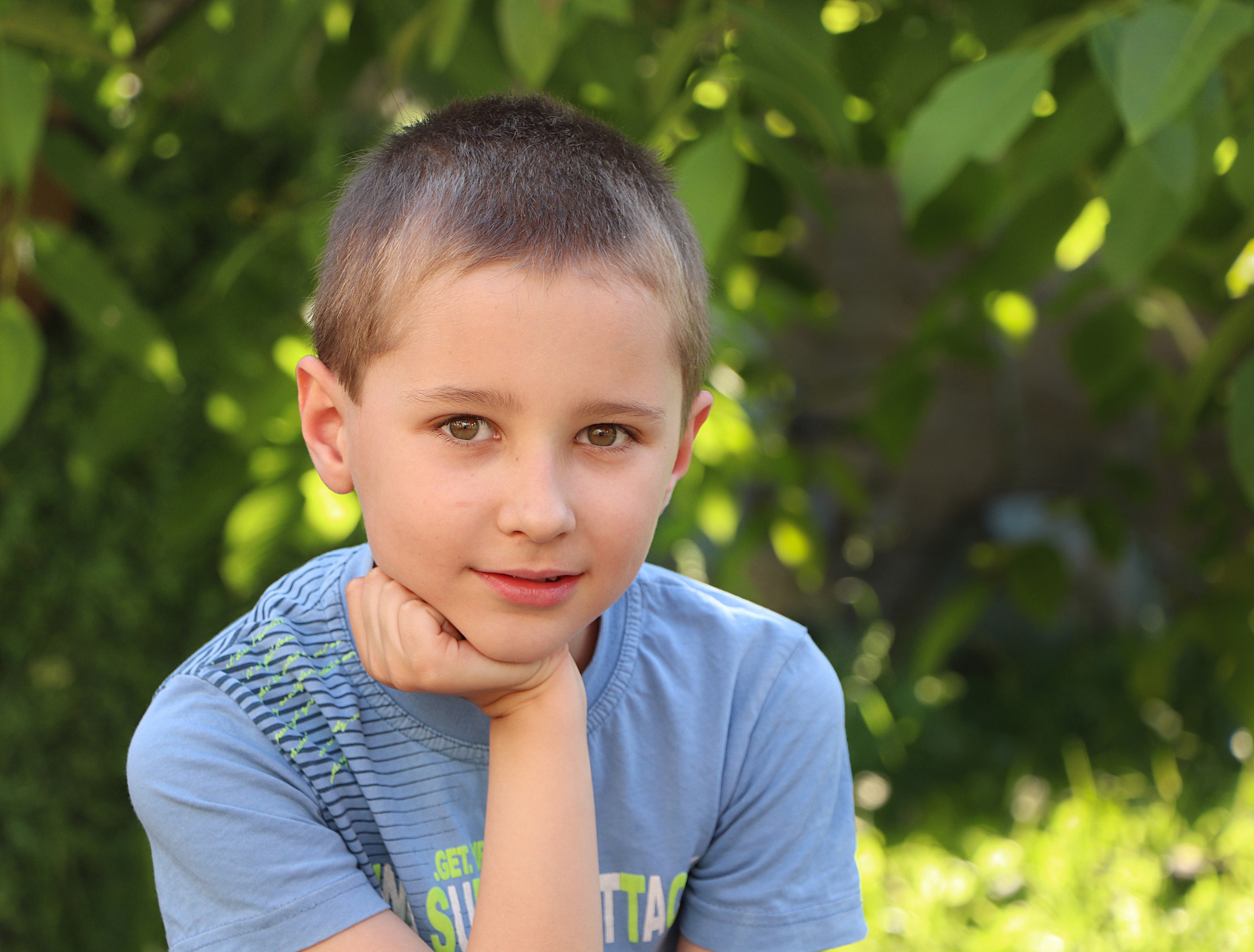 портрет школьника на фоне зелени, крупный портрет с акцентом на глаза