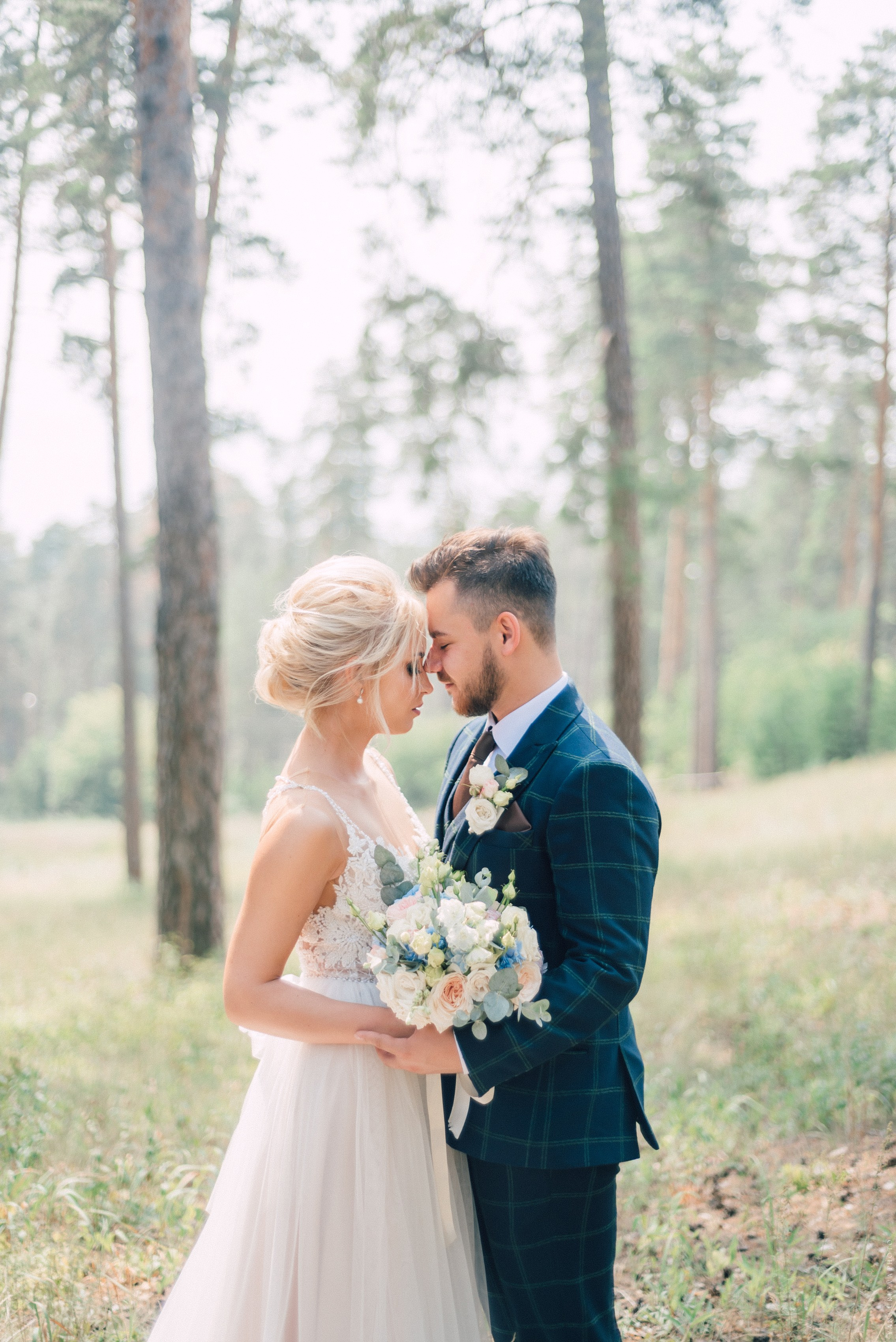 Жених и невеста обнимаются в сосновом лесу fine art съемка