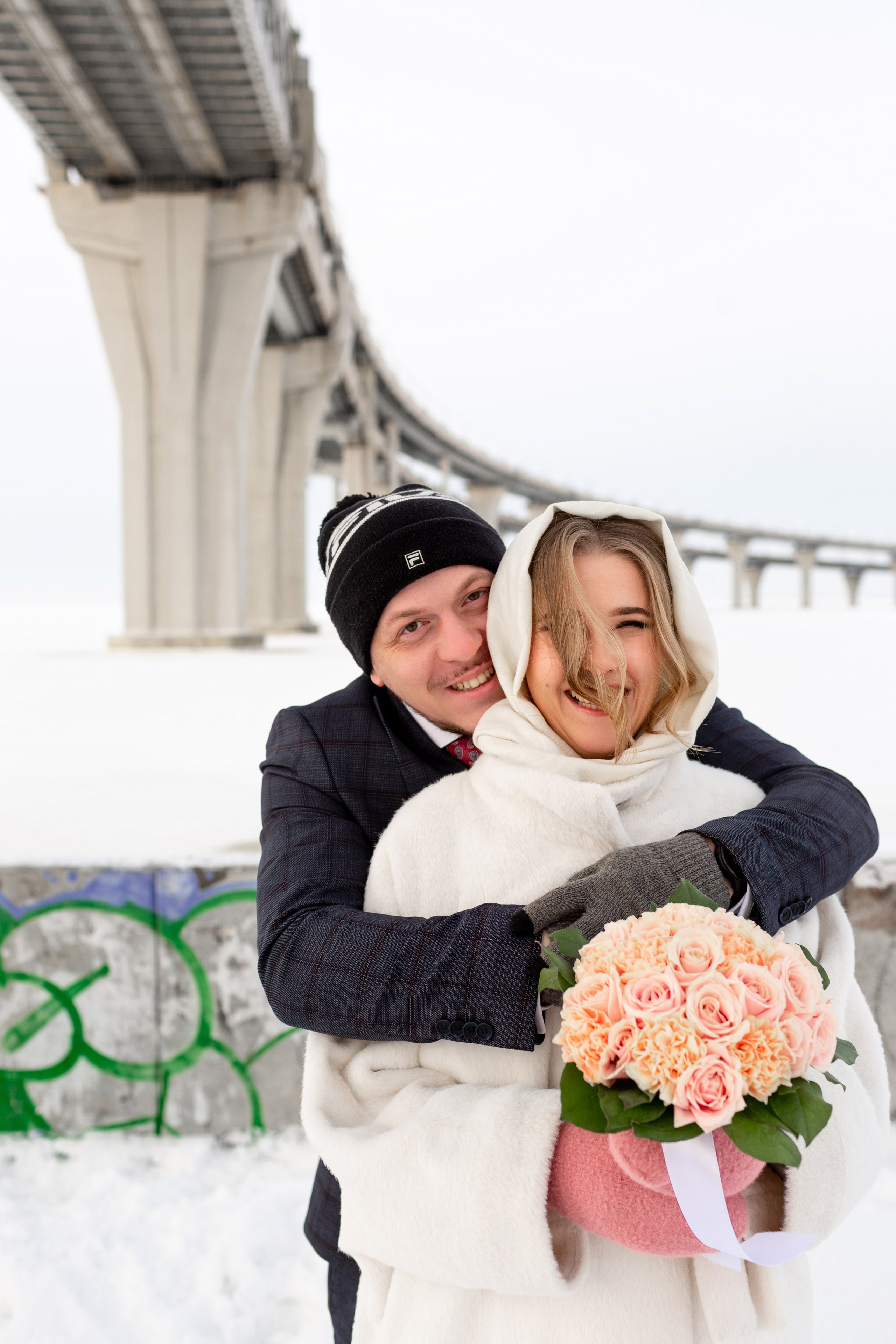 Зимняя свадьба, жених обнимает невесту на фотопрогулке