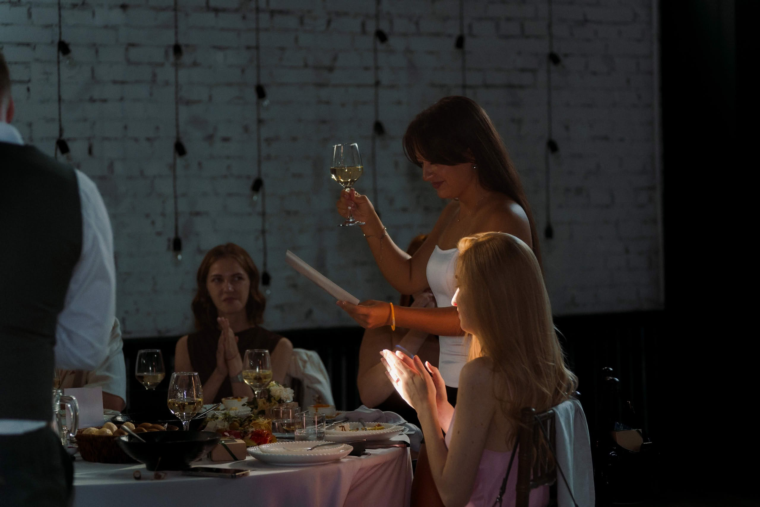 Гостья поднимает бокал за праздничным столом в Event Rest