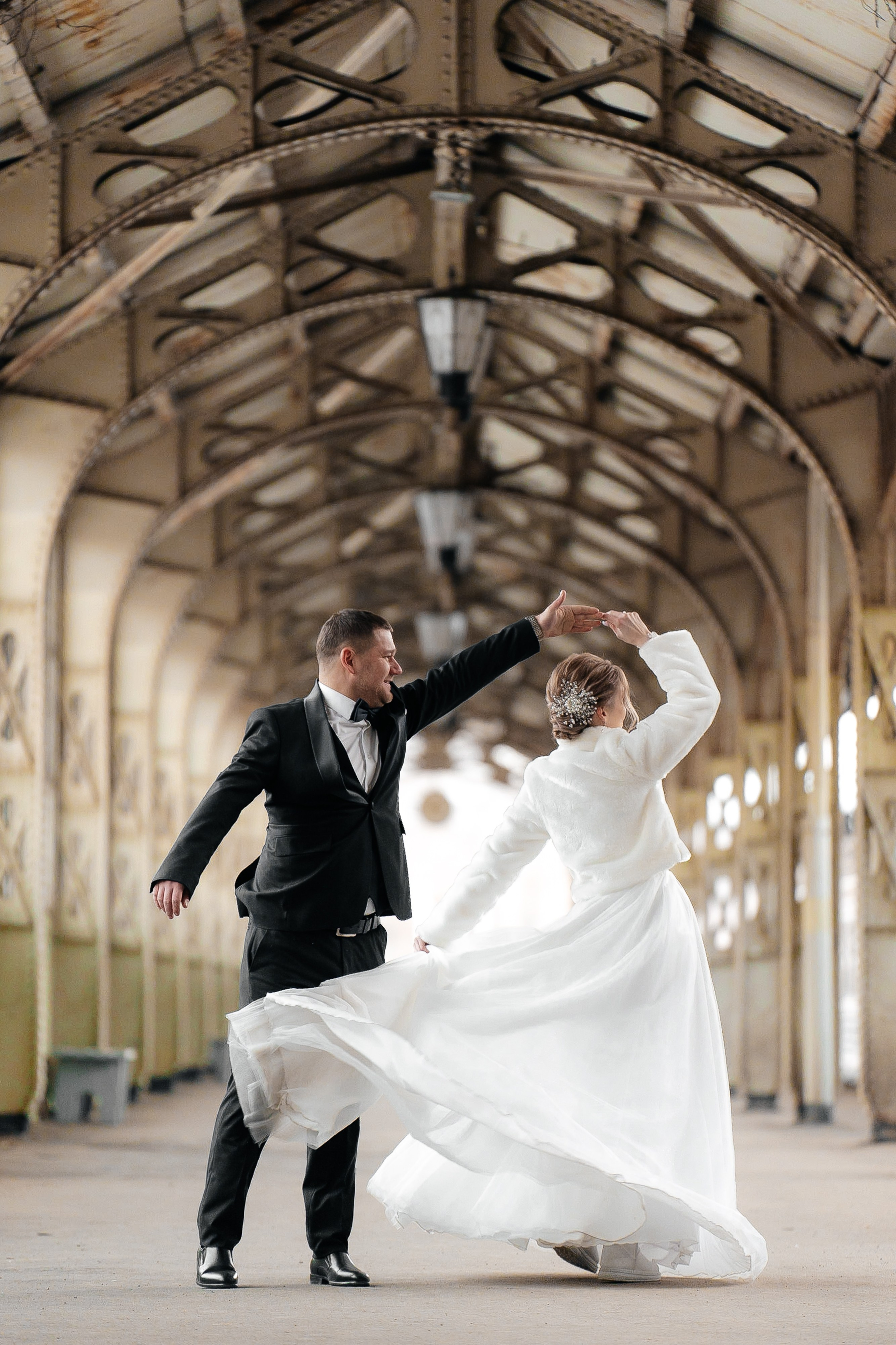 невеста кружится в танце и жениха на перроне Витебского вокзала свадебная фотосессия зимой 