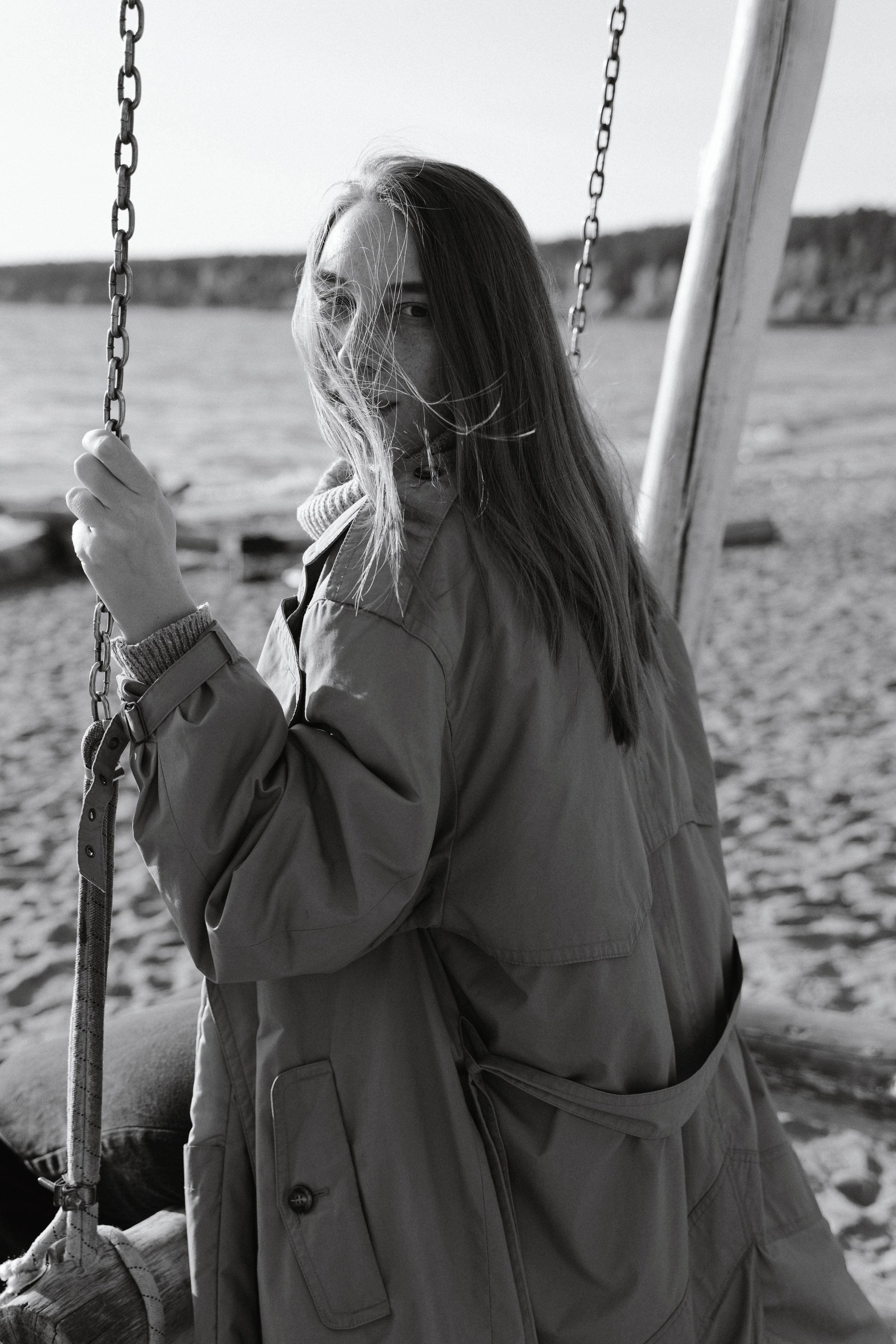 Фото девушки с развивающимися волосами на пляже Академгородка на качелях 