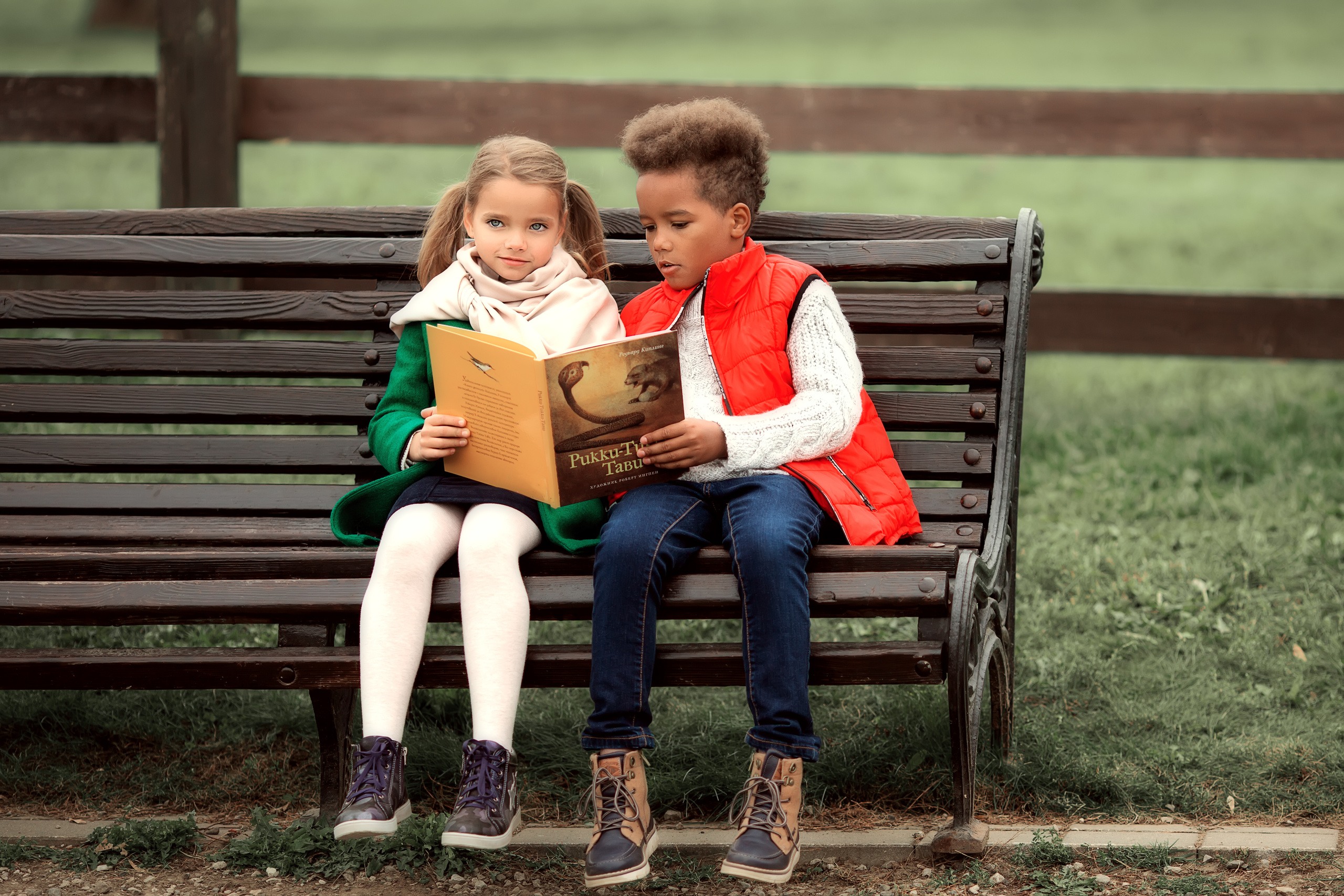Мальчик с девочкой в парке с книжкой