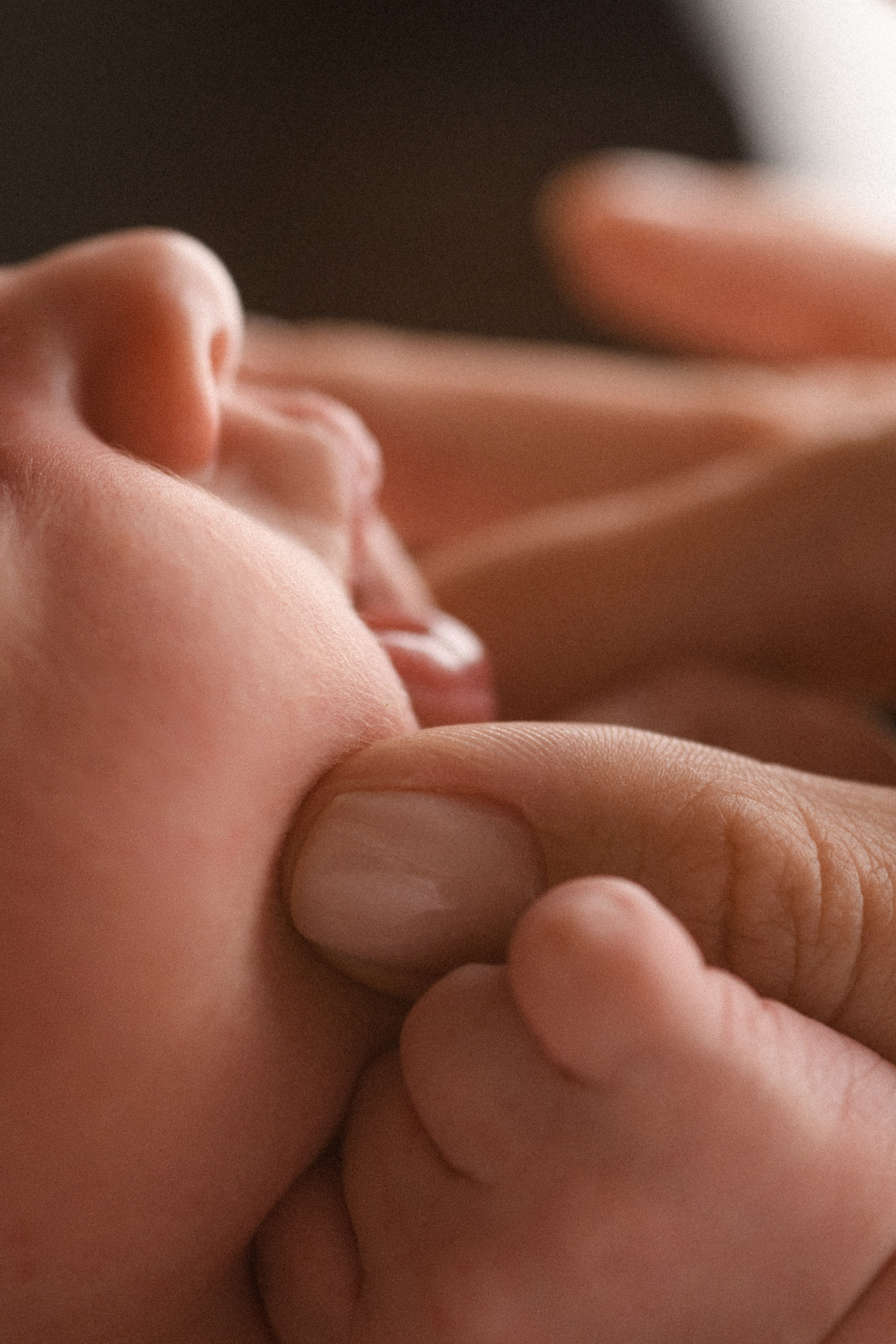 Милая макро-фотография новорожденного малыша, мама нежно сжимает его пухлые щёчки в ньюборн фотостудии "В капусте" в Липецке