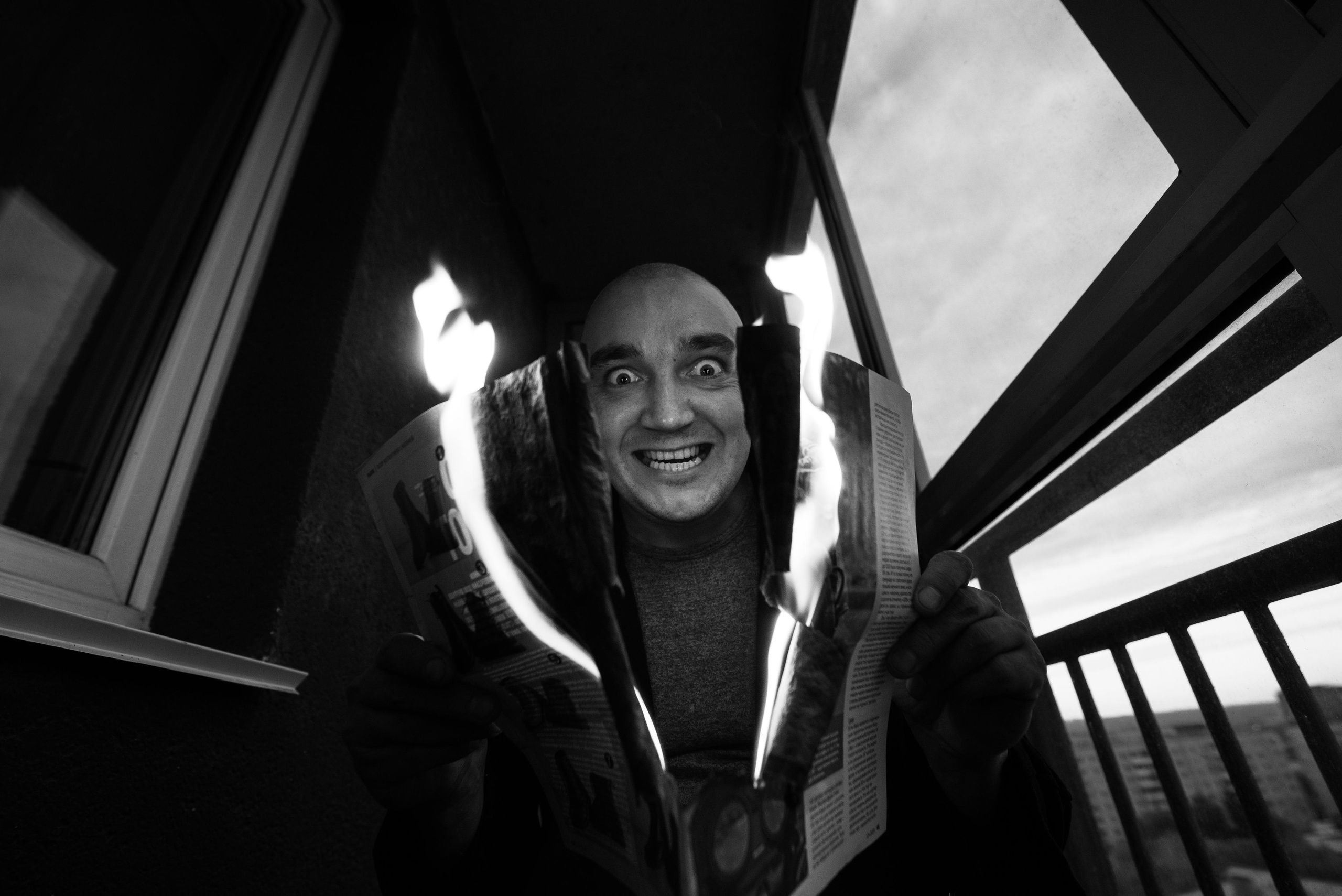 портрет мужчины с горящей газетой