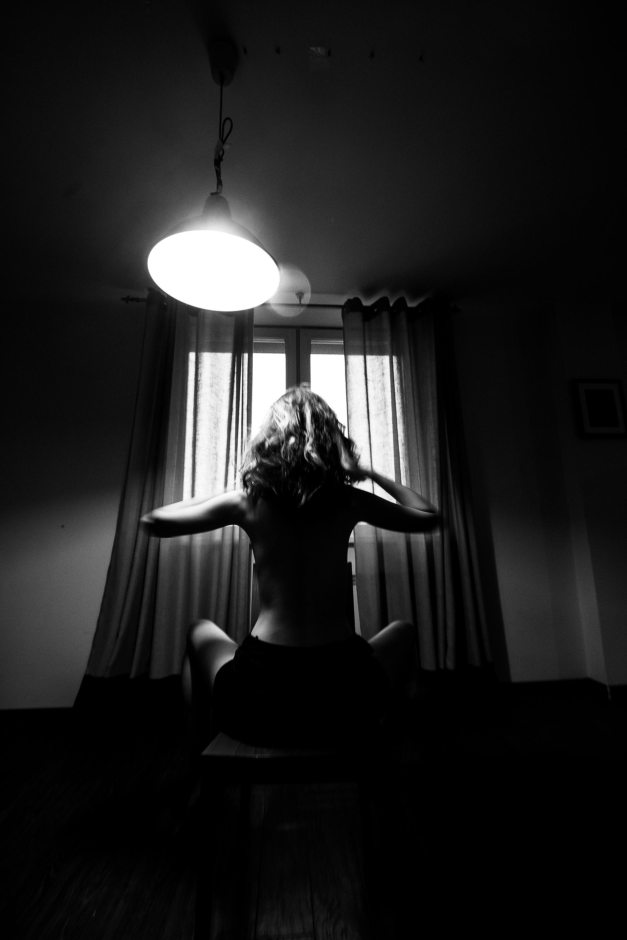 девушка на стуле под лампой