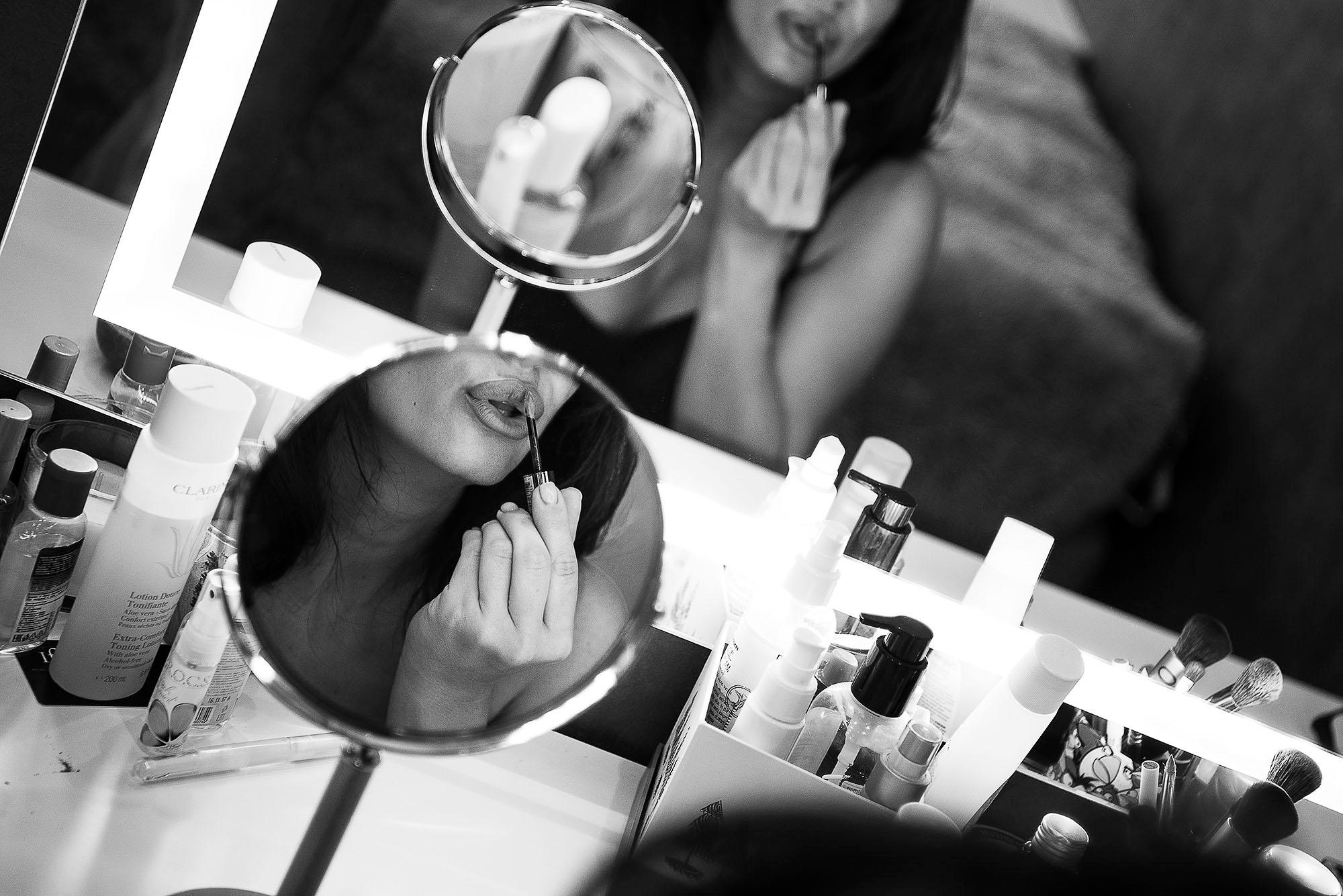 отражение в зеркале. девушка красит губя