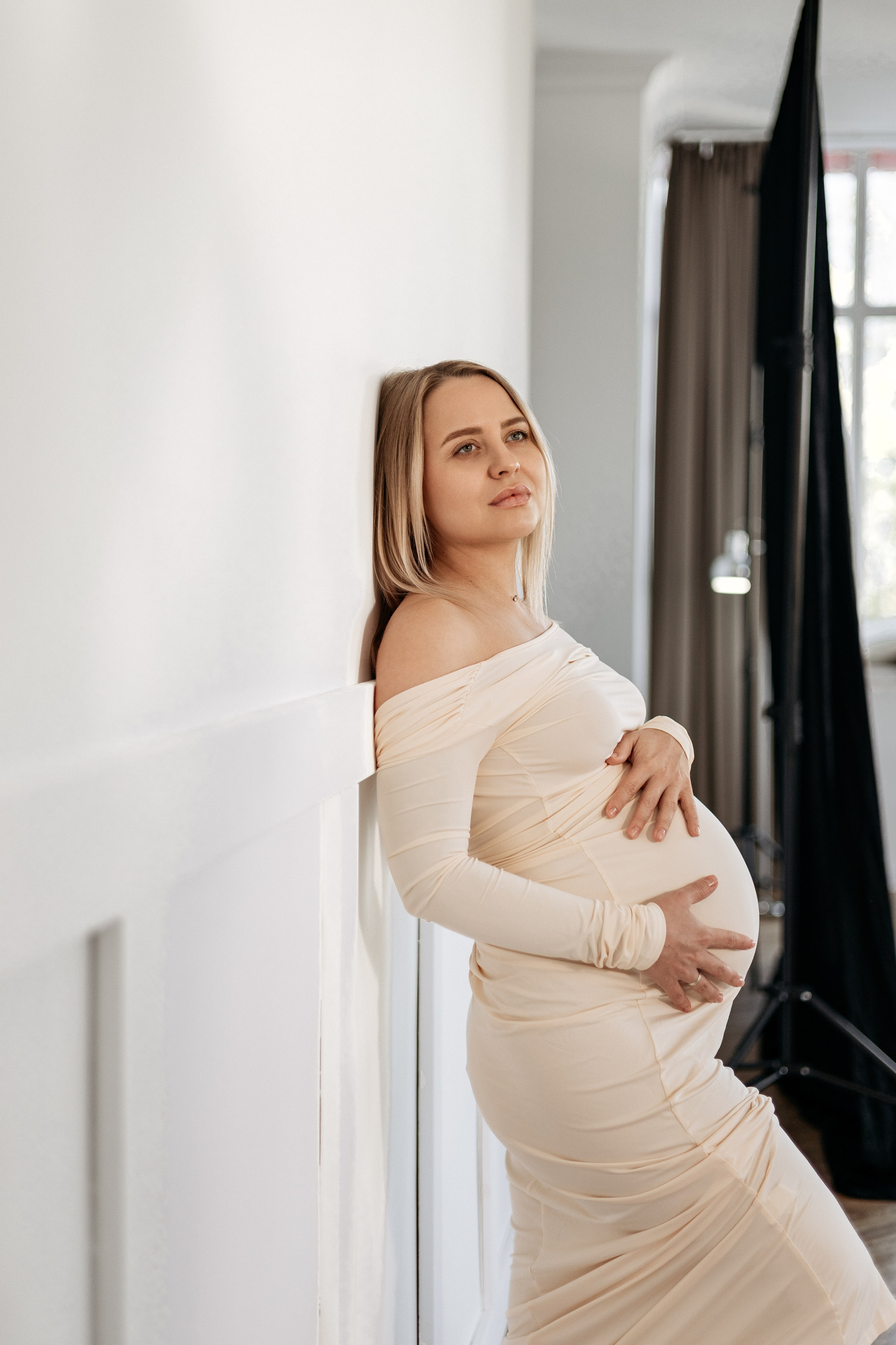  Беременная в облаках: будущая мама лежит на белой постели среди белых подушек, словно парит в облаках со своим животом.