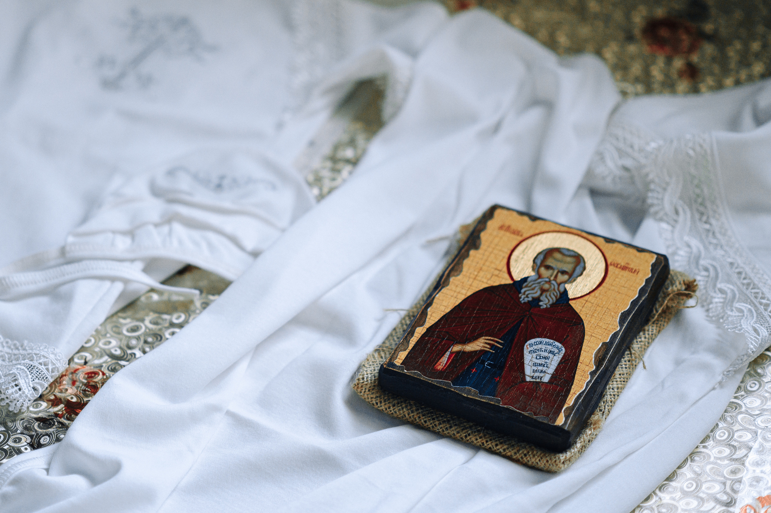 на пеленке лежит икона