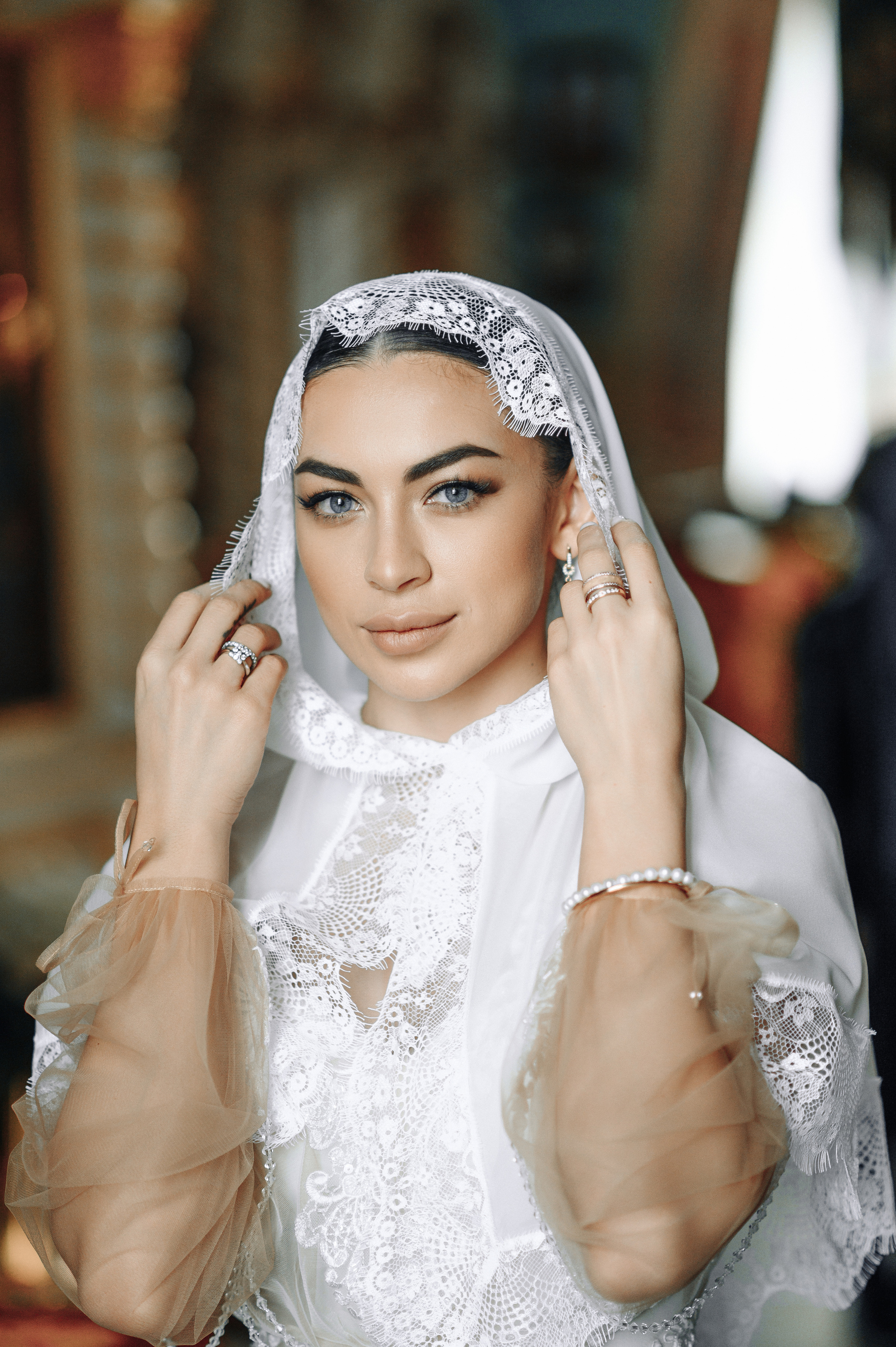 молодая красивая девушка держит платок на голове рукам