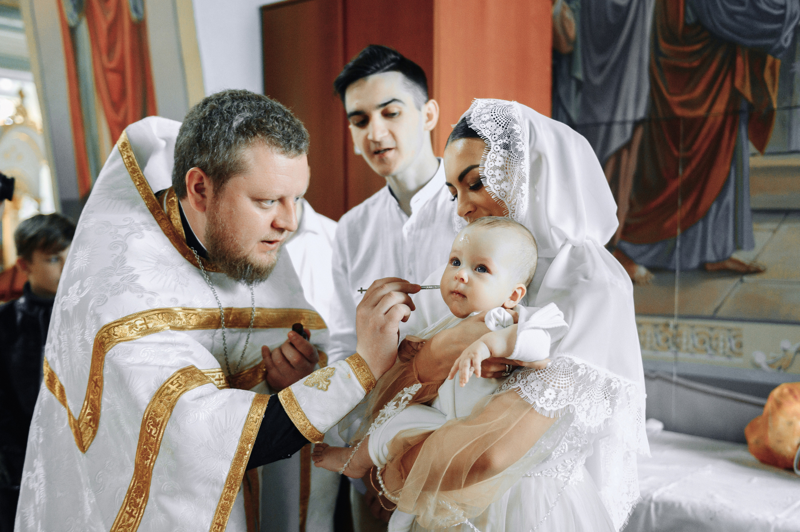во время крещения батюшка совершает помаз младенца