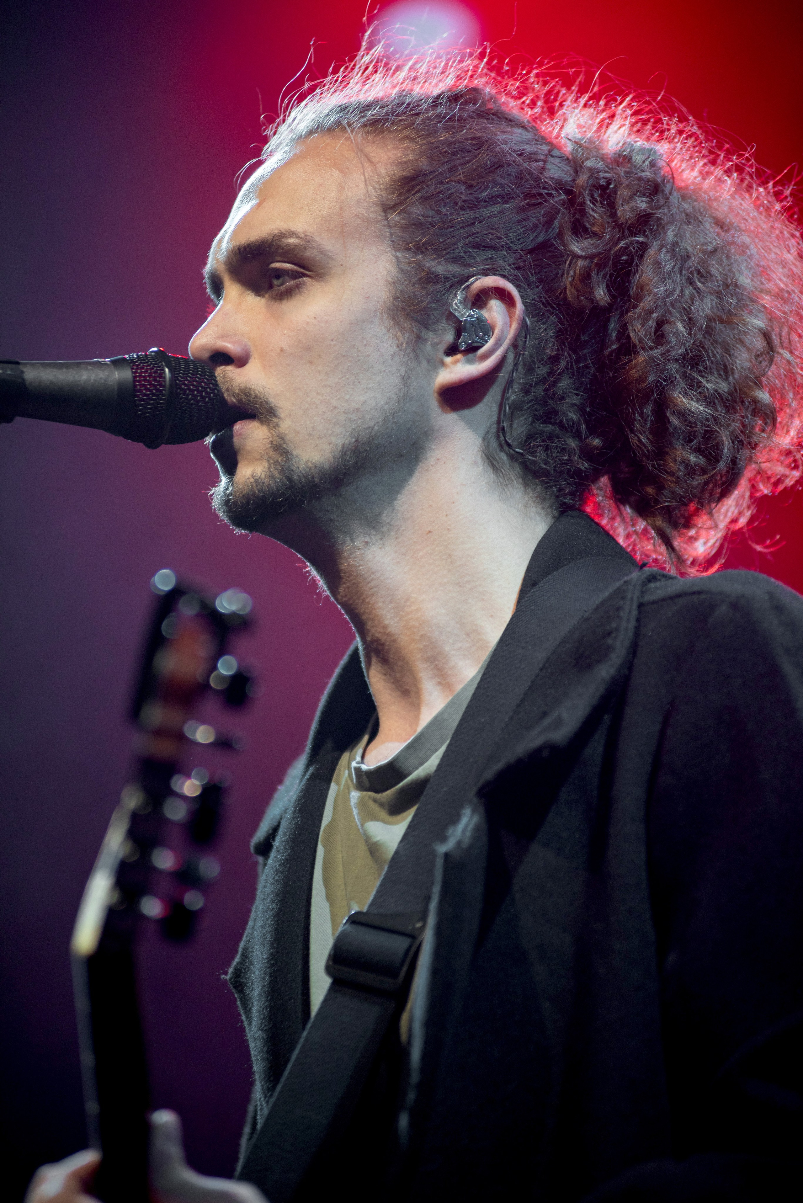 Портрет вокалиста группы «Лампабикт» у микрофона на фоне красных огней