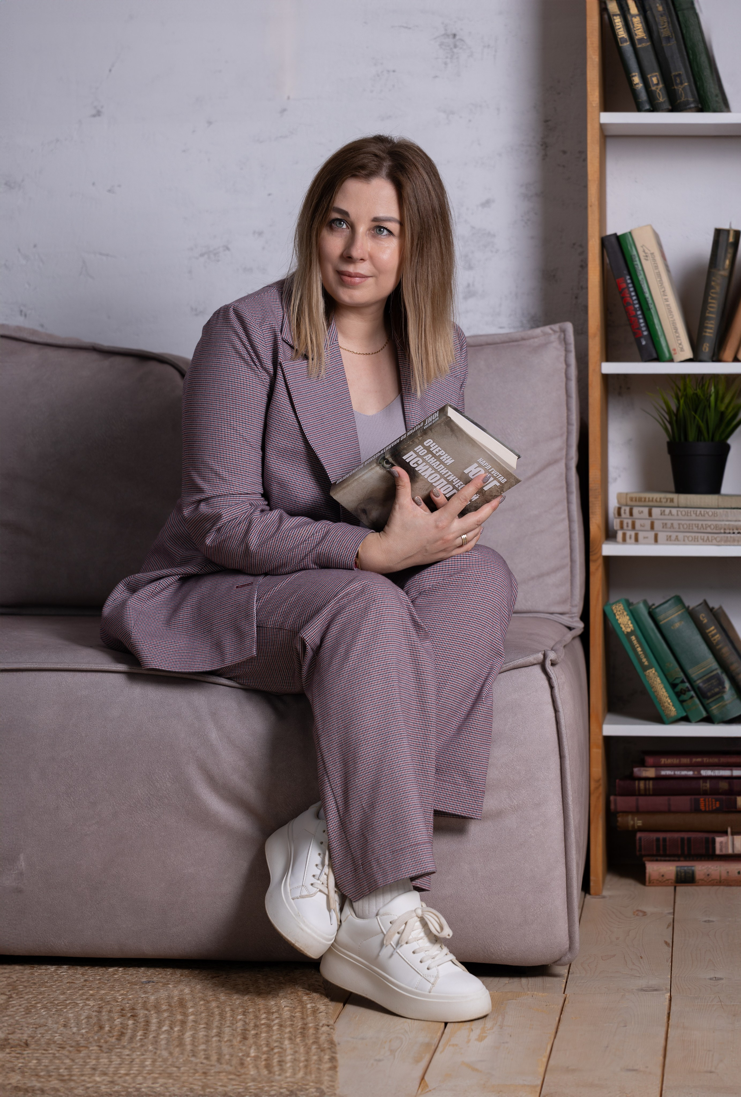 фотосессия в студии девушка сидит на диване и держит книгу в руках