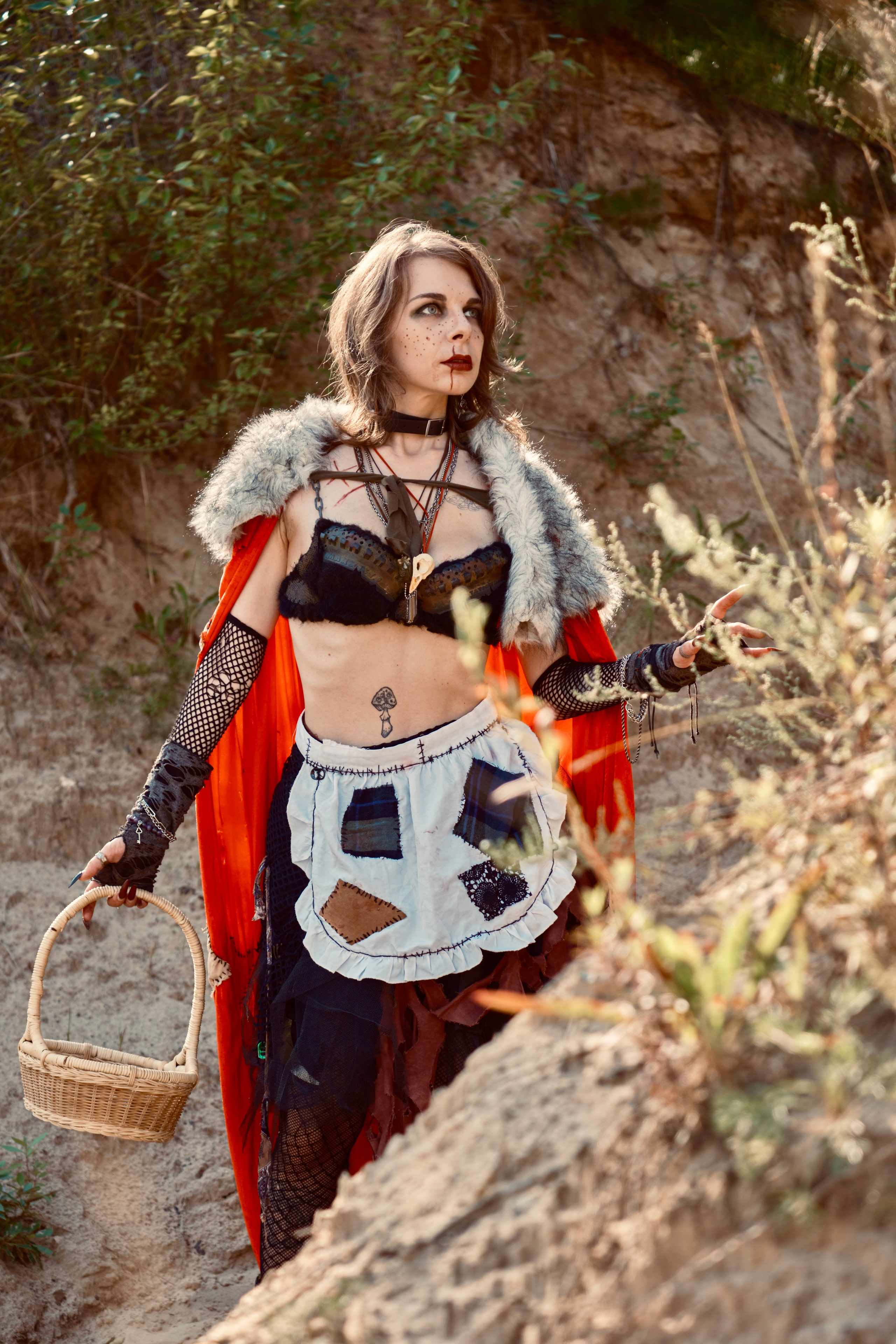 Девушка в красном плаще с корзиночкой гуляет в лесу