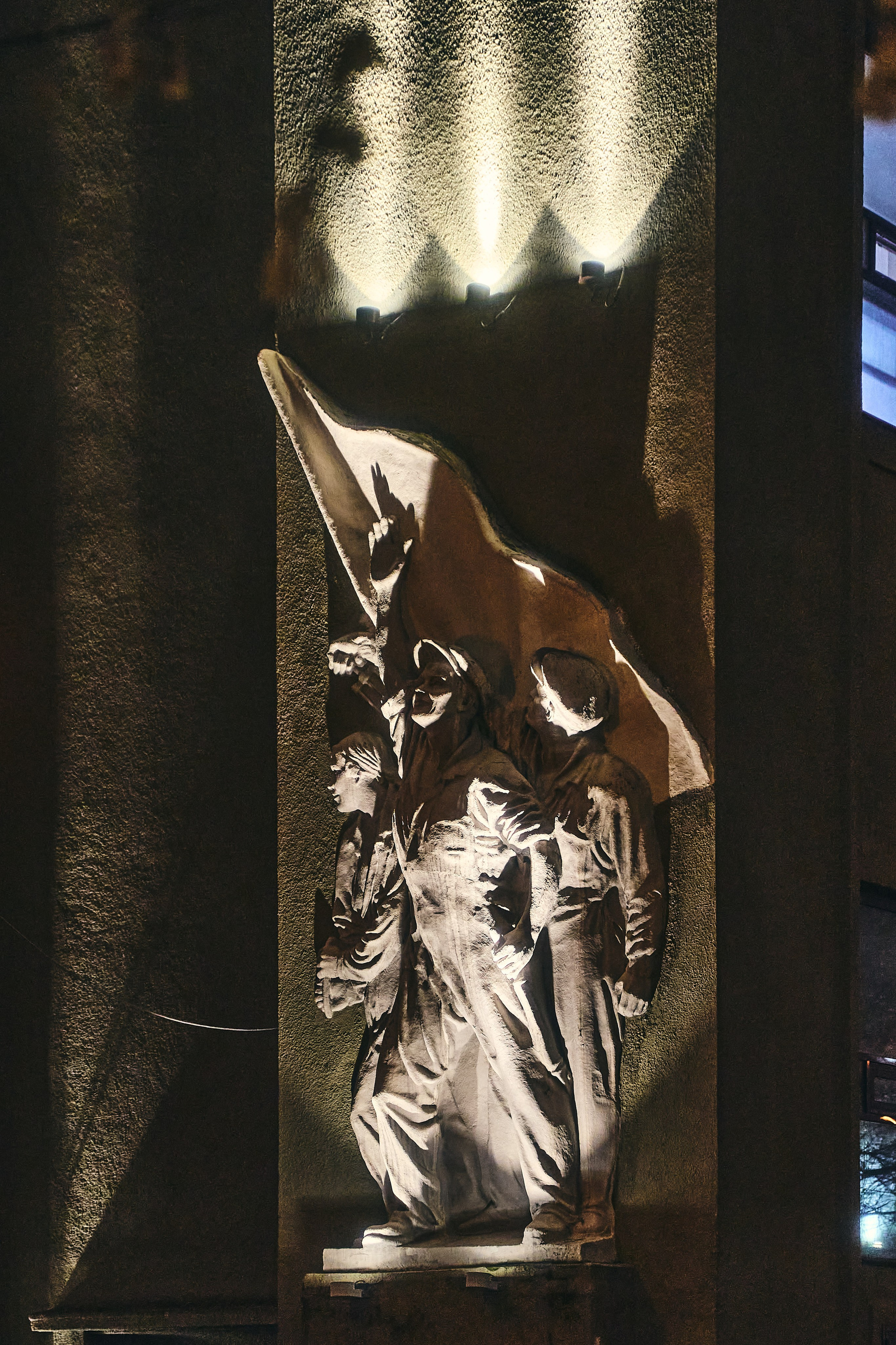 Ночное архитектурное фото с барельефом рабочих на здании центральной тяговой подстанции Московского метрополитена